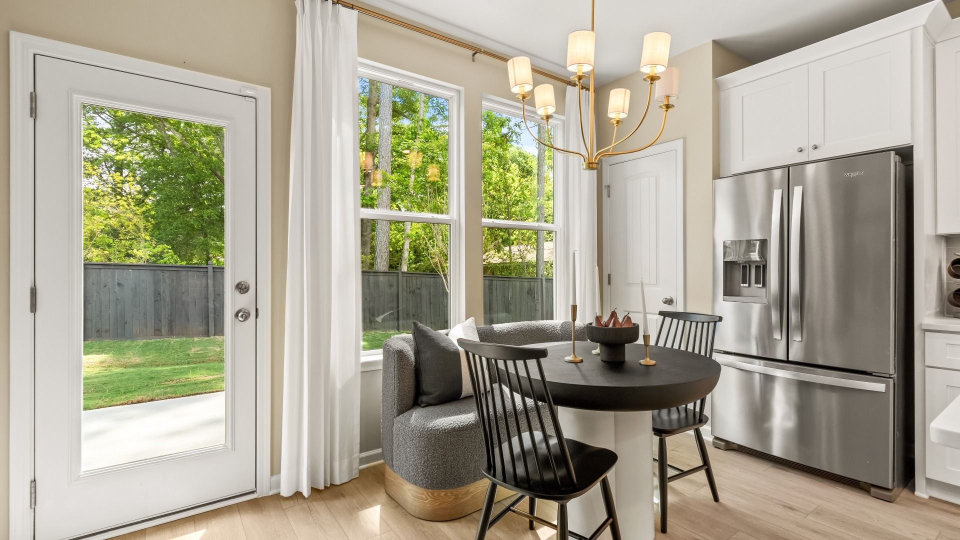 Breakfast area with abundant natural light and views of kitchen and backyard at Enclave at Evergreen in Fairburn, GA.