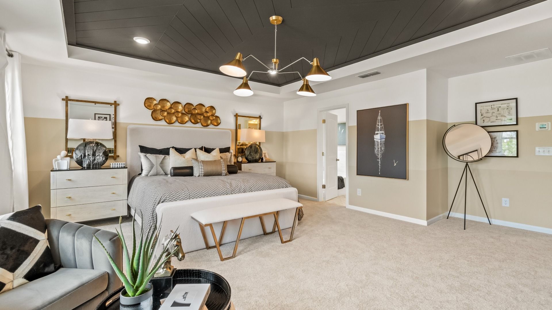 Spacious upstairs primary suite with sitting area and tray ceiling in new construction single family home in Fairburn, GA.