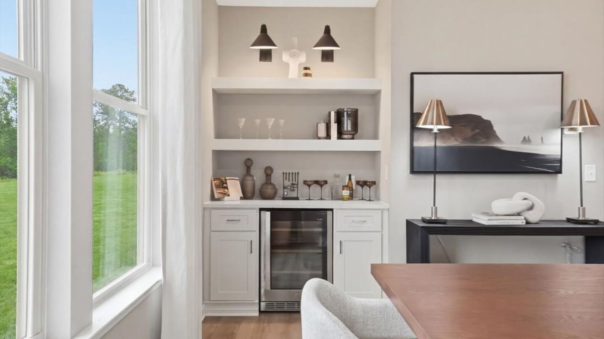 Stonefield dining room with built-in beverage area featuring wine cooler, cabinets, and open shelving at Brighton.