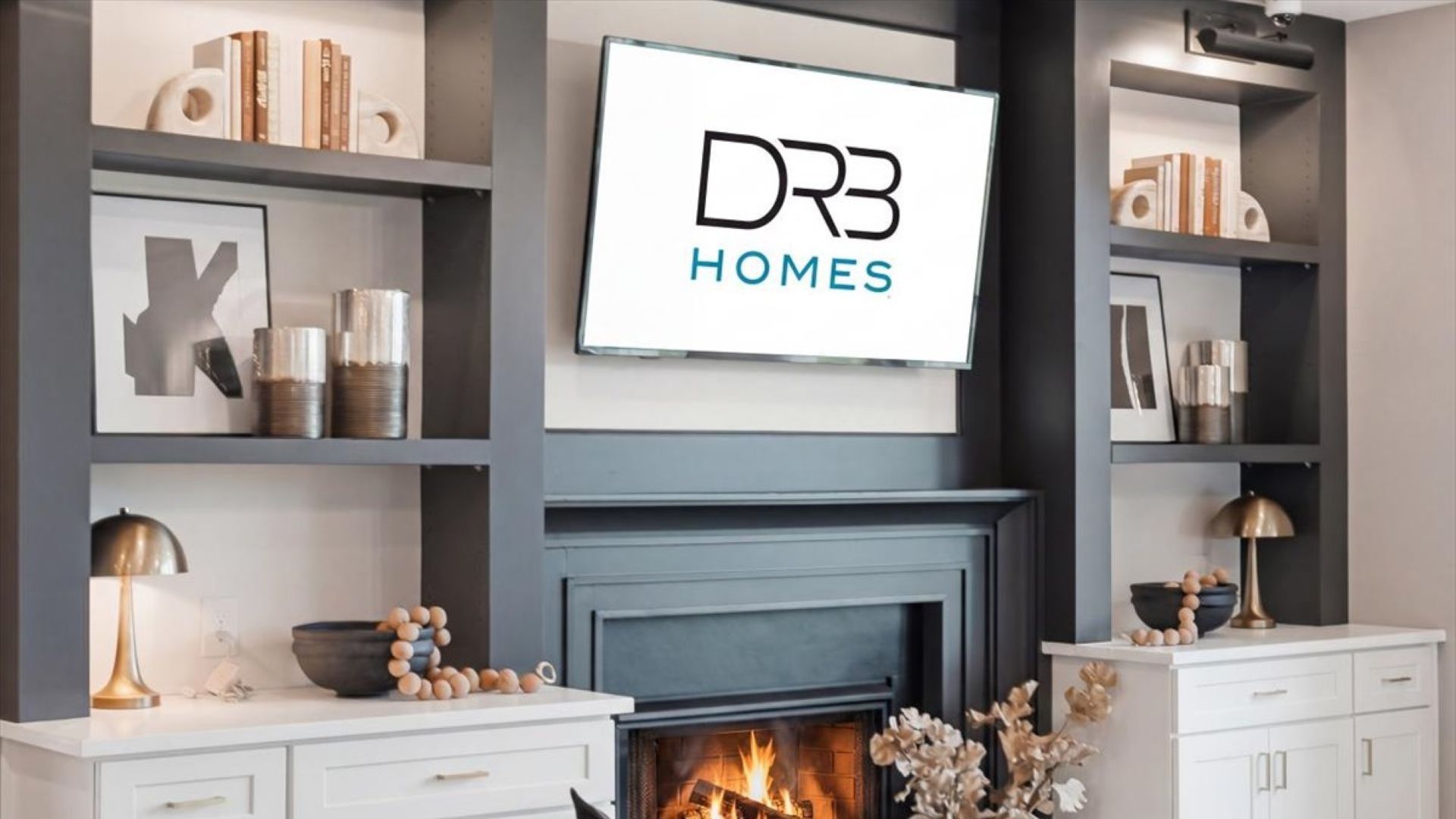Stonefield family room with gas fireplace, built-in shelving, and additional cabinetry for storage at Brighton.