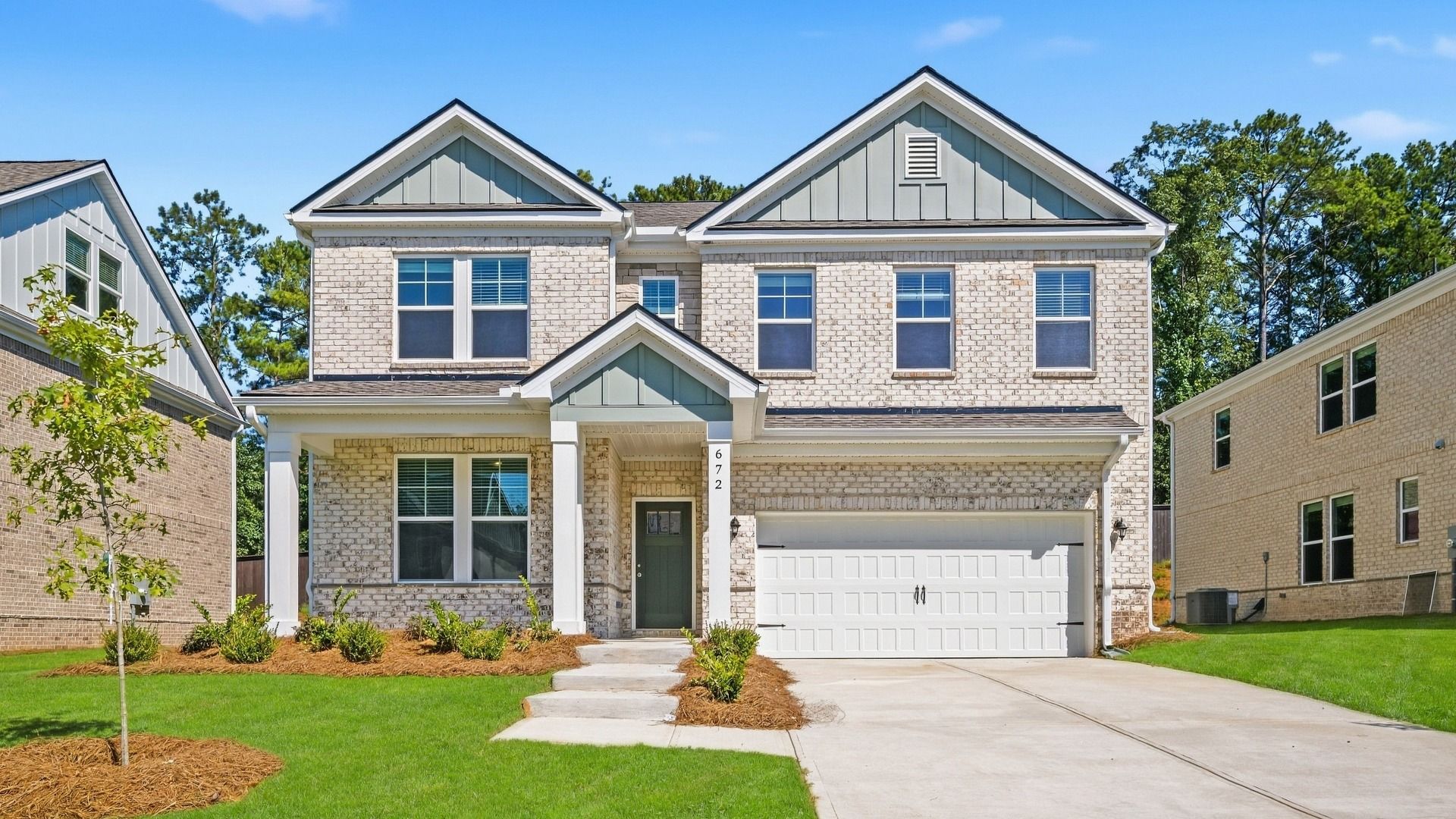 Wagener two-story white brick home with subtle stone and shake siding accent at Bowers Farm in McDonough, GA.