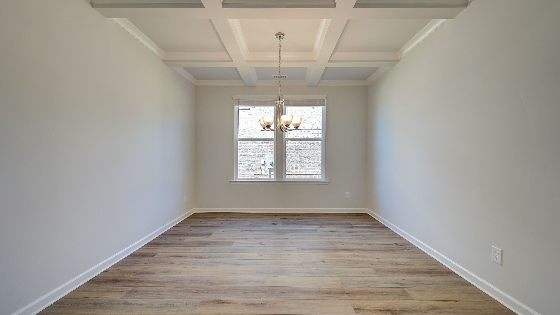 Elegant Wagener dining room with coffered ceiling, LVP flooring, and modern finishes at Bowers Farm in McDonough, GA.