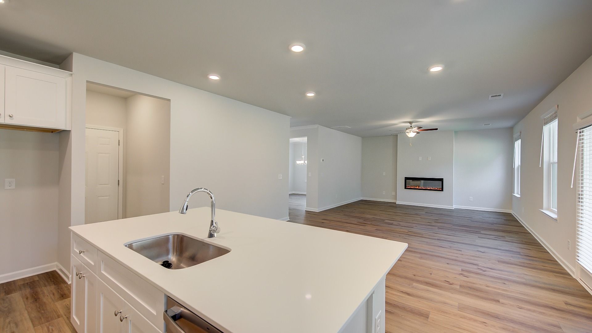 Modern open-concept Wagener kitchen with white cabinetry, natural light, and large island with seating at Bowers Farm.