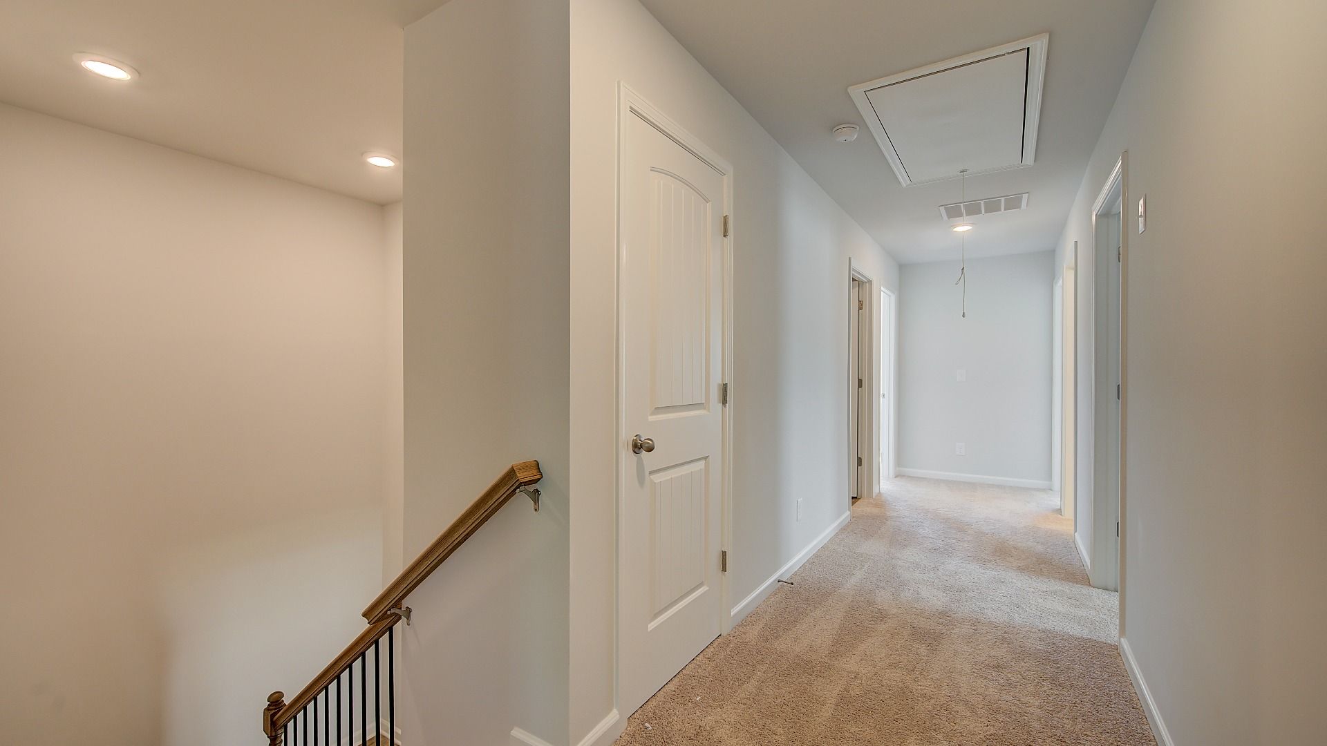 Wagener upstairs landing with open hallway and carpet flooring at Bowers Farm in McDonough, GA.