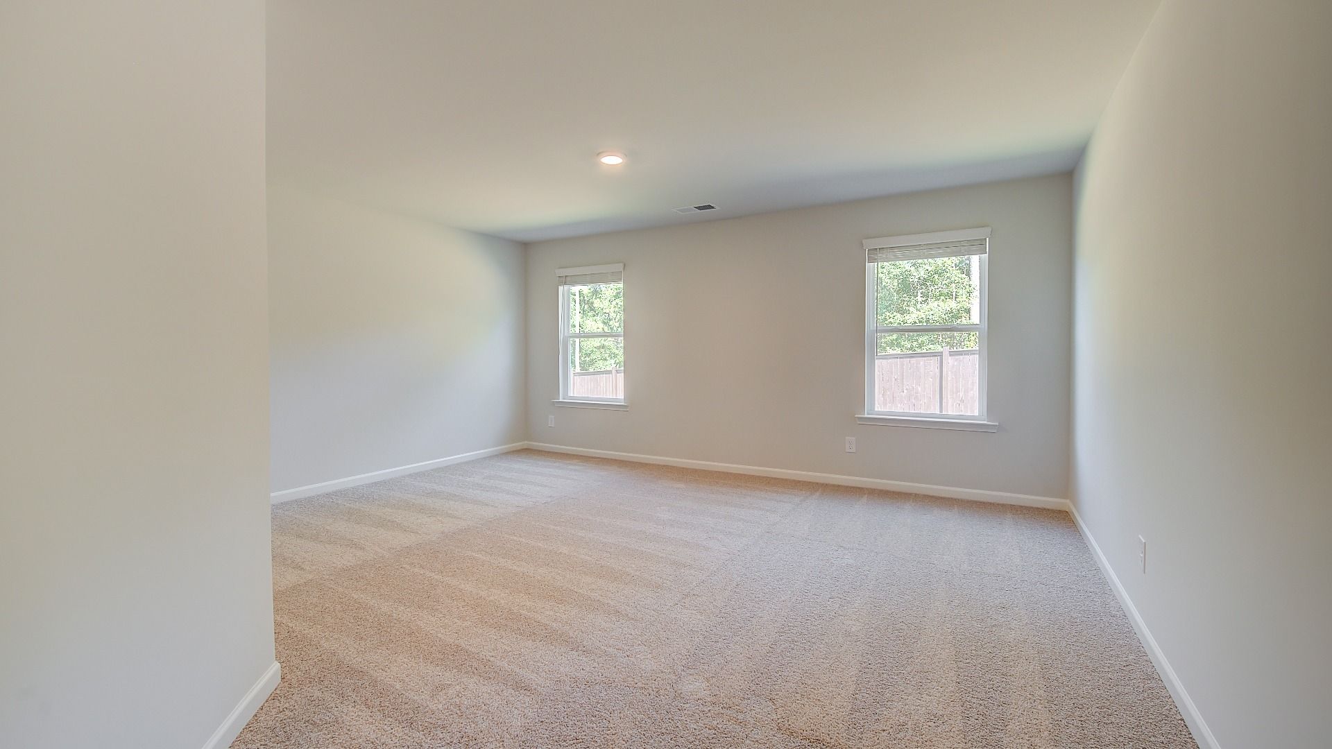Spacious Wagener loft for lounge or work use with carpet flooring and natural light at Bowers Farm in McDonough, GA.