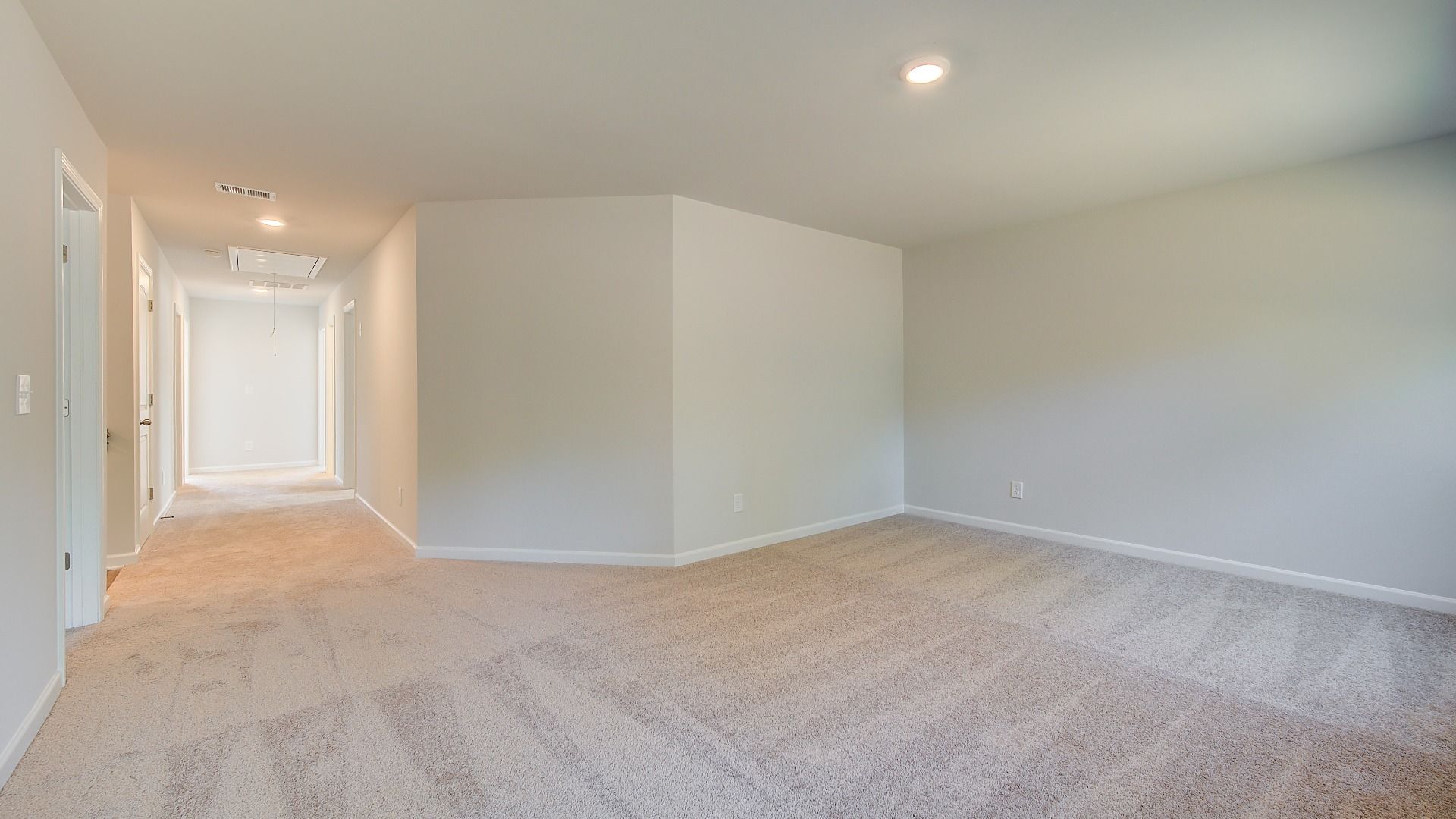 Spacious Wagener loft for lounge or work use with carpet flooring and natural light at Bowers Farm in McDonough, GA.