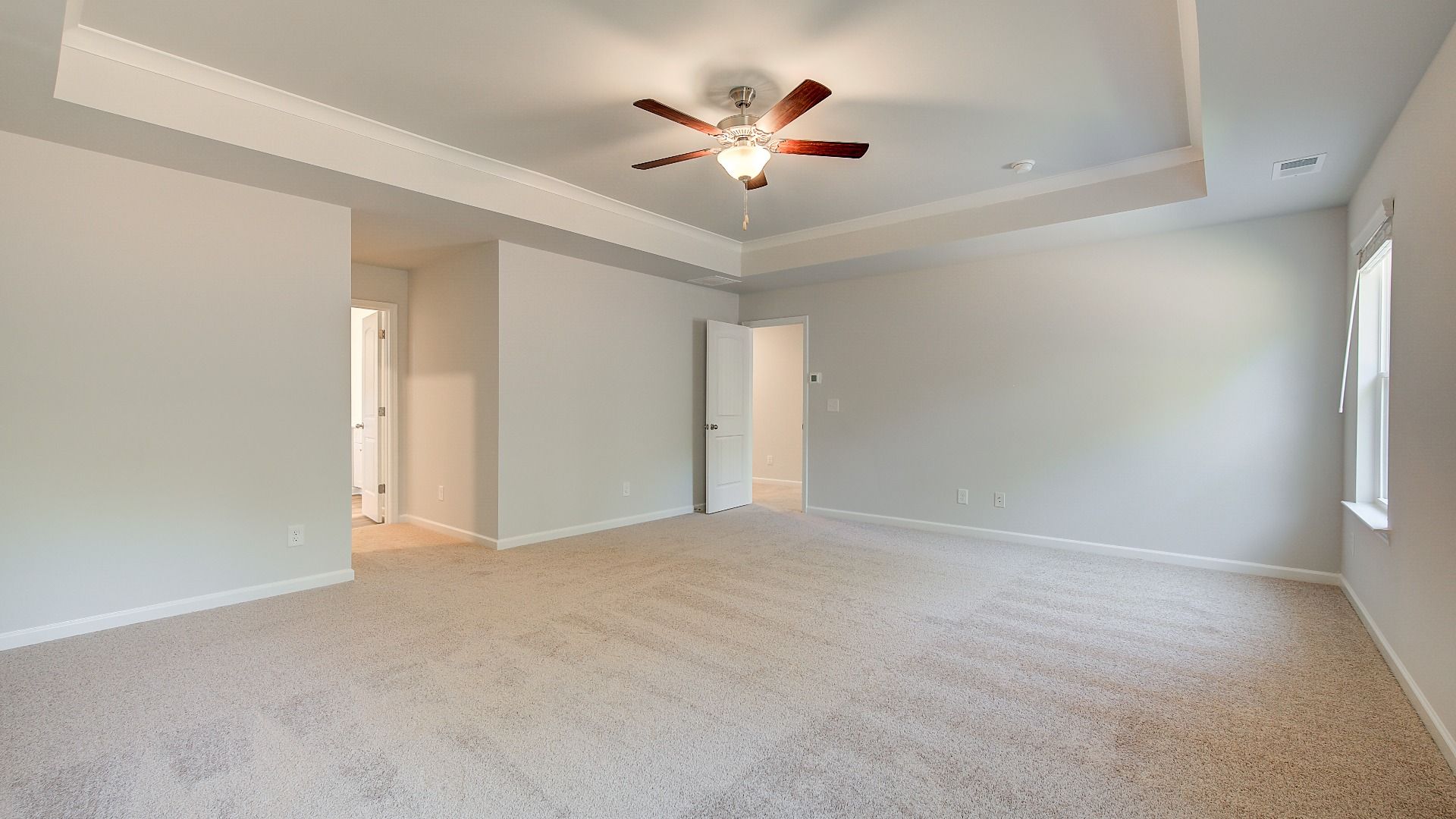 Luxurious Wagener primary suite with spacious room, carpet flooring, and neutral modern finishes at Bowers Farm.