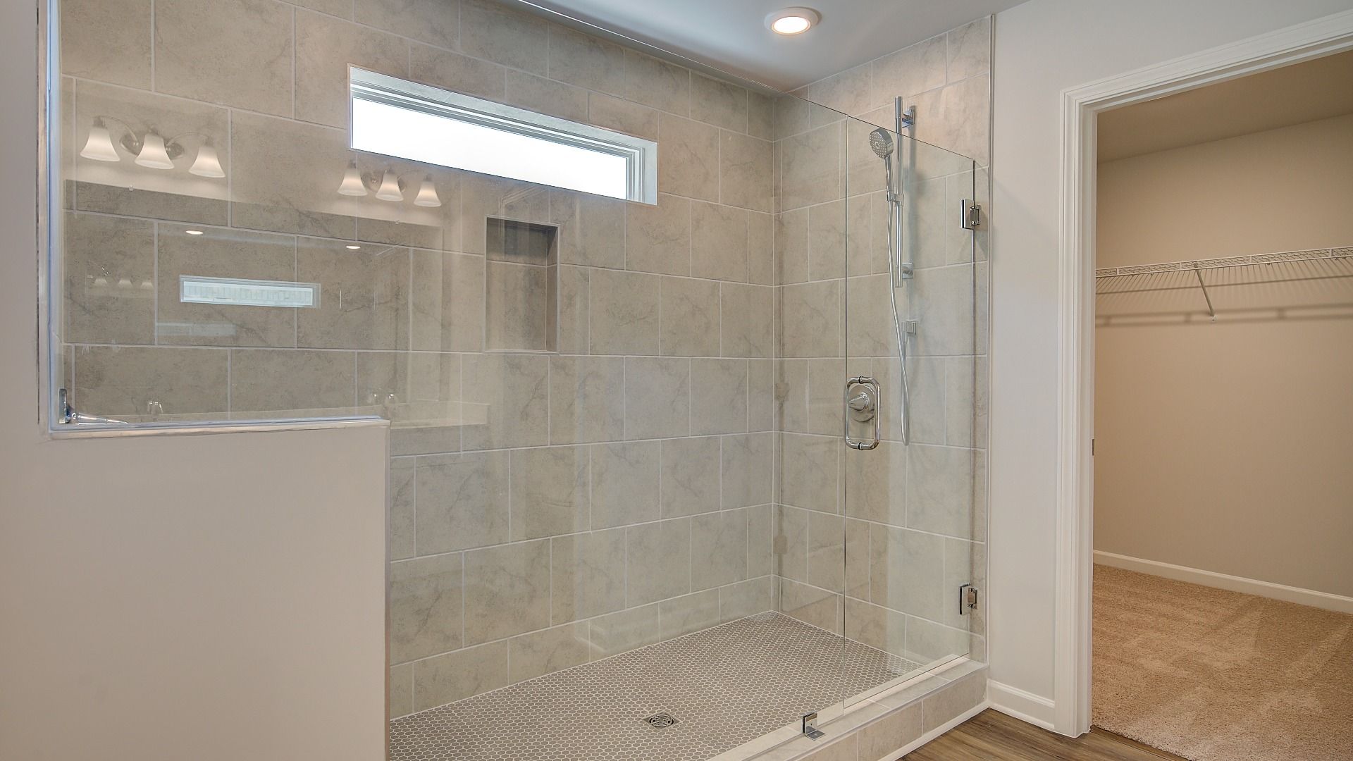 Wagener primary bath with elegant modern detail and tiled walk-in shower at Bowers Farm in McDonough, GA.