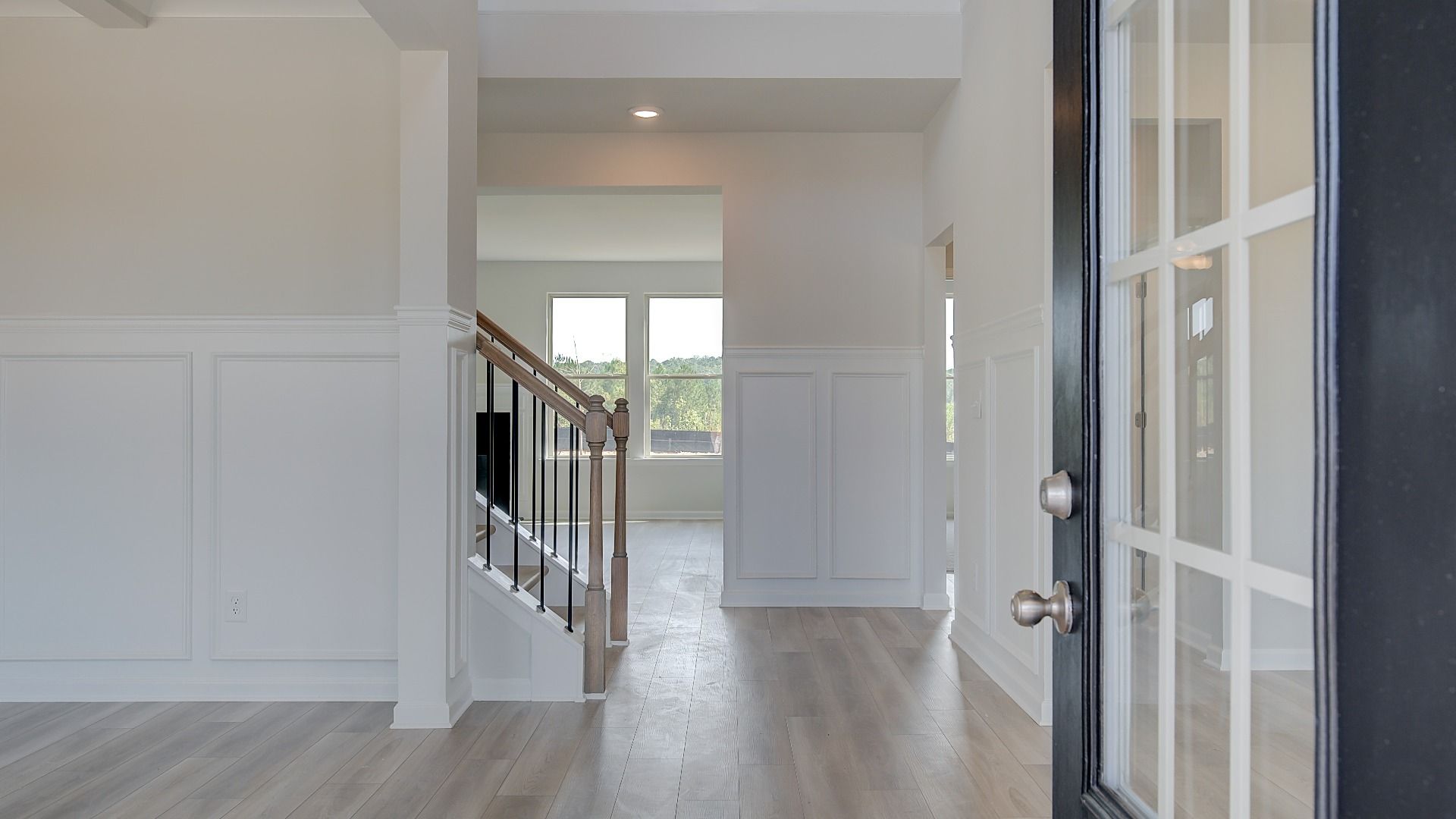 Front entry with glass panels and LVP flooring at single family home at Brighton in Locust Grove, GA.