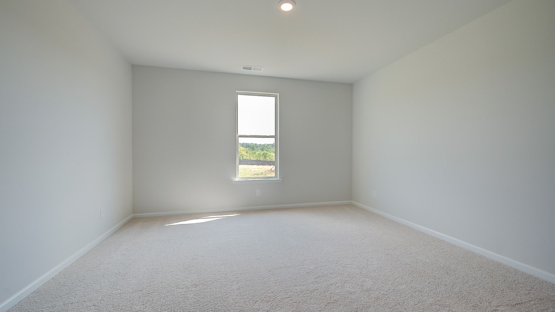 Guest room with carpet flooring and natural light in the Clarity at Brighton in Locust Grove, GA.