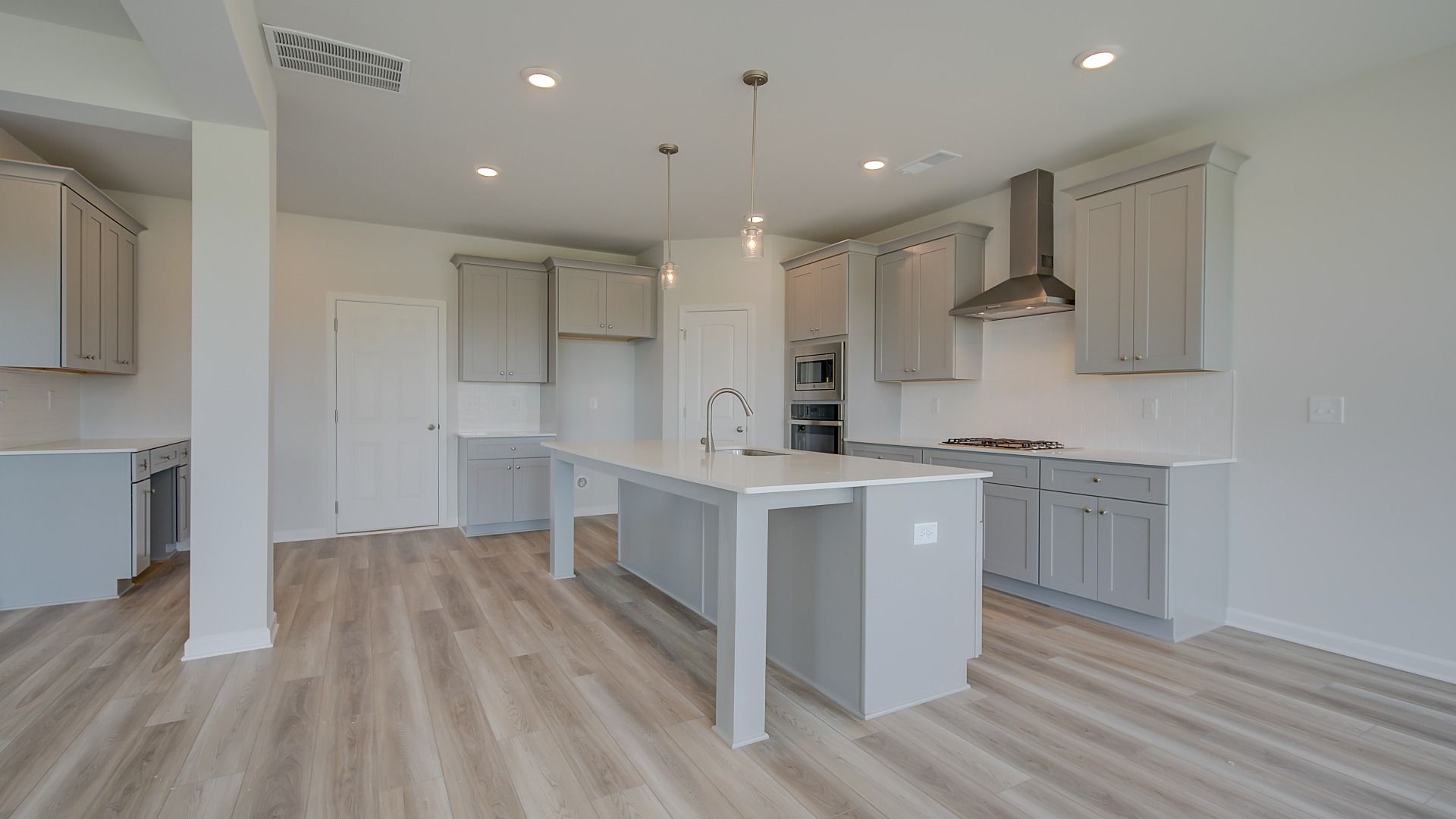 Modern kitchen with neutral cabinetry and oversized island in the Clarity at Brighton in Locust Grove, GA.