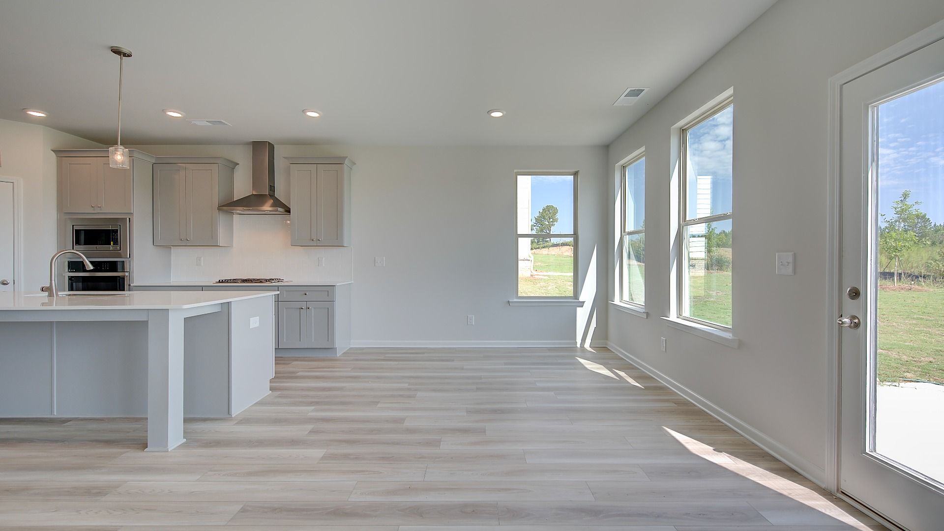 Bright breakfast room connected to kitchen with LVP flooring and view of covered porch in the Clarity at Brighton.