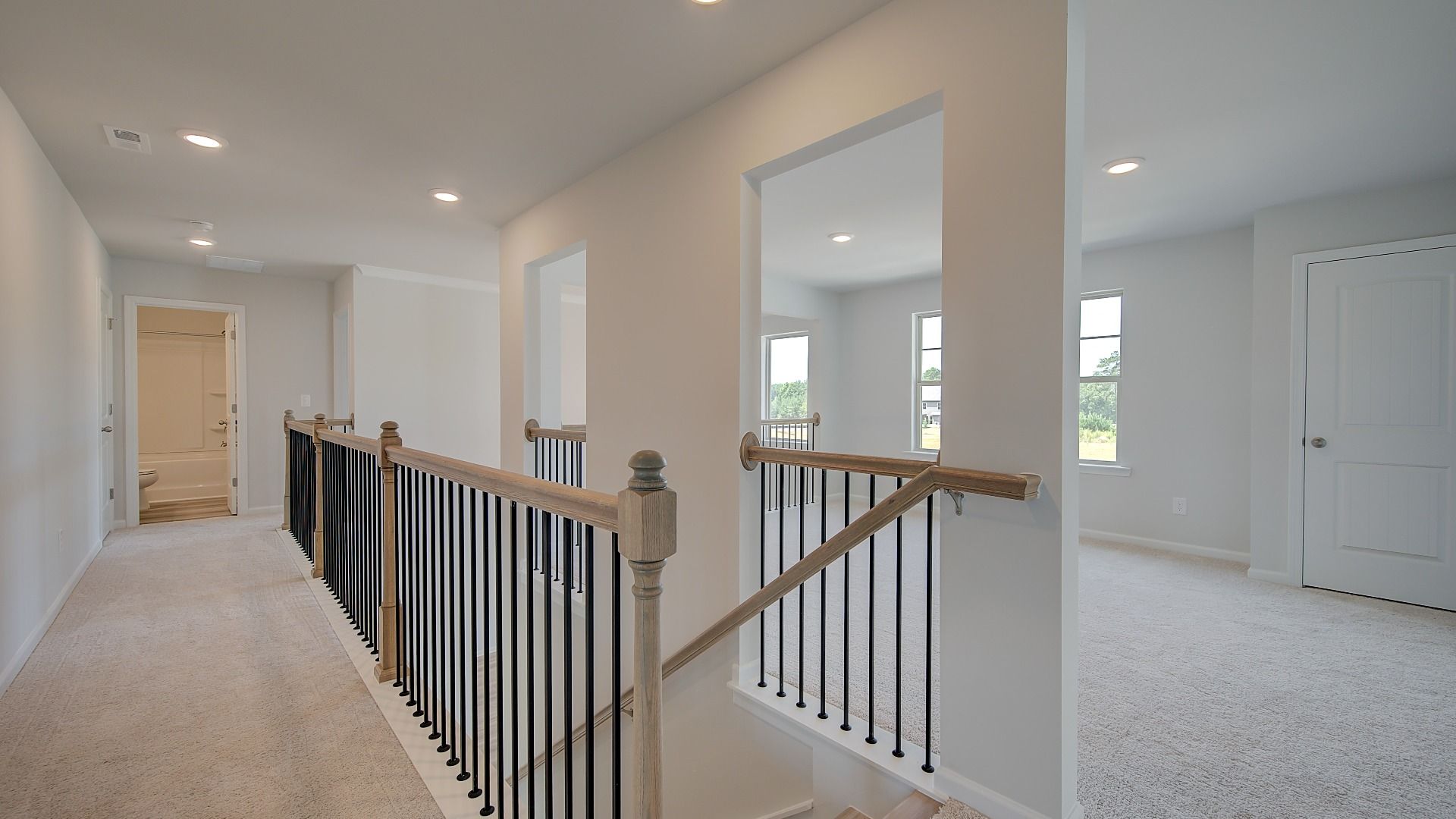 Clarity upstairs landing with carpet flooring and loft entry at Brighton in Locust Grove, GA.