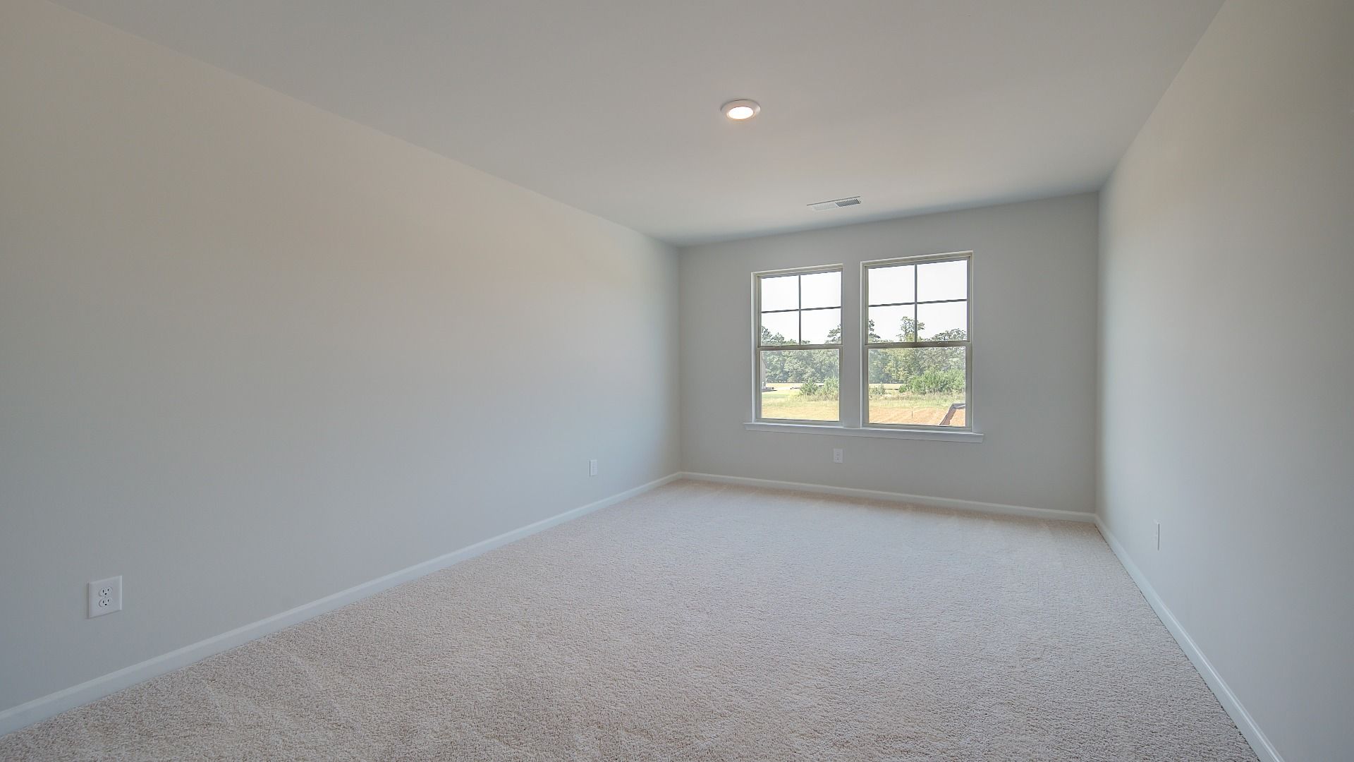 Secondary bedroom with neutral walls, carpet flooring, and natural light in the Clarity at Brighton in Locust Grove, GA.
