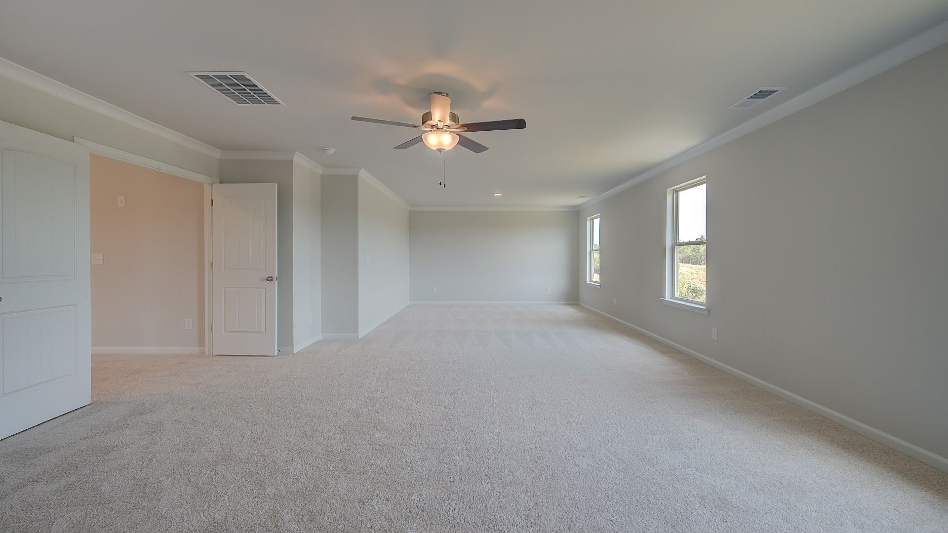 Clarity primary sitting room connected to the suite with carpet flooring and neutral walls at Brighton in Locust Grove, GA.