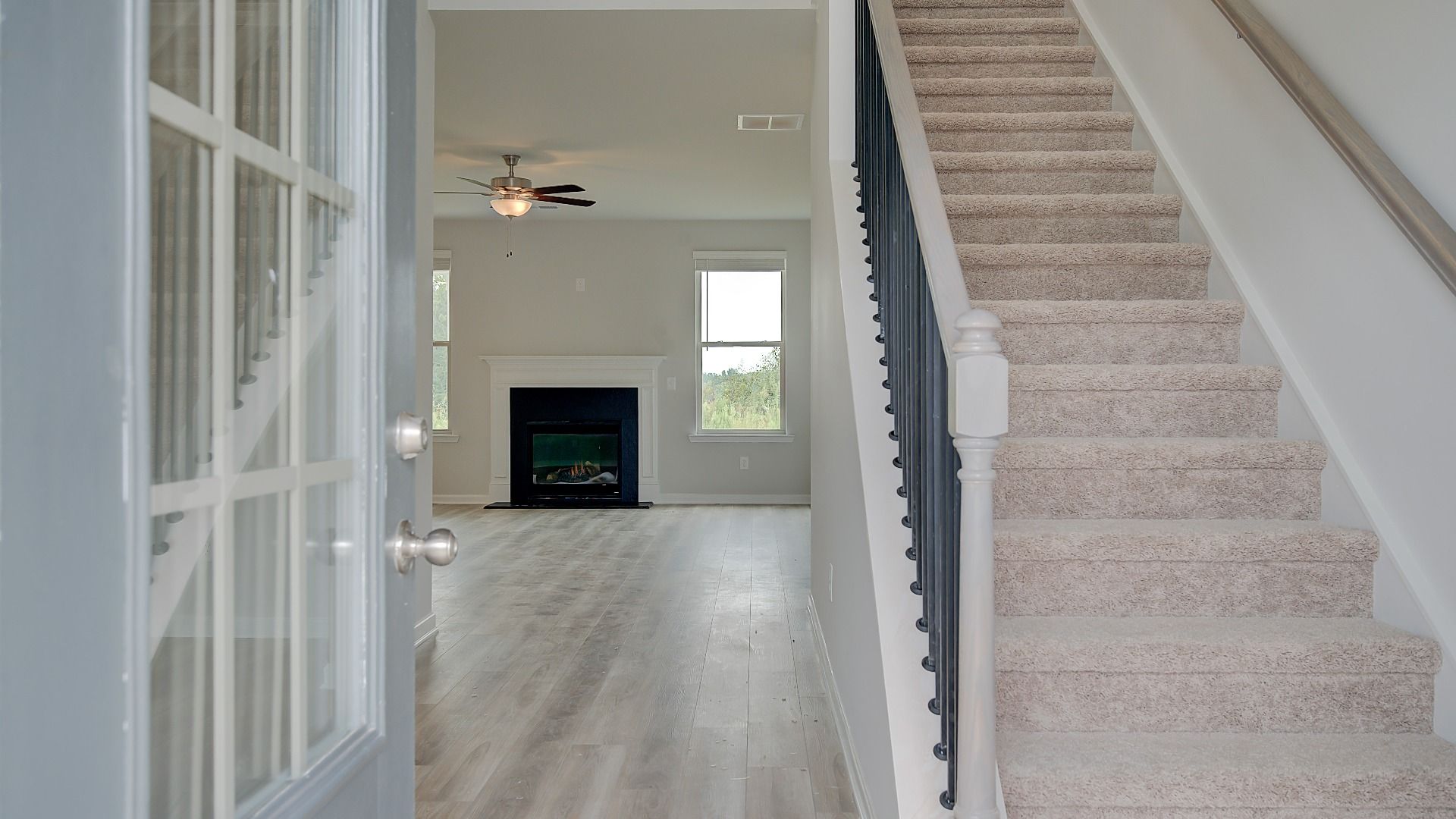 Meridian II foyer entry with glass-panel front door and LVP flooring at Brighton in Locust Grove, GA.