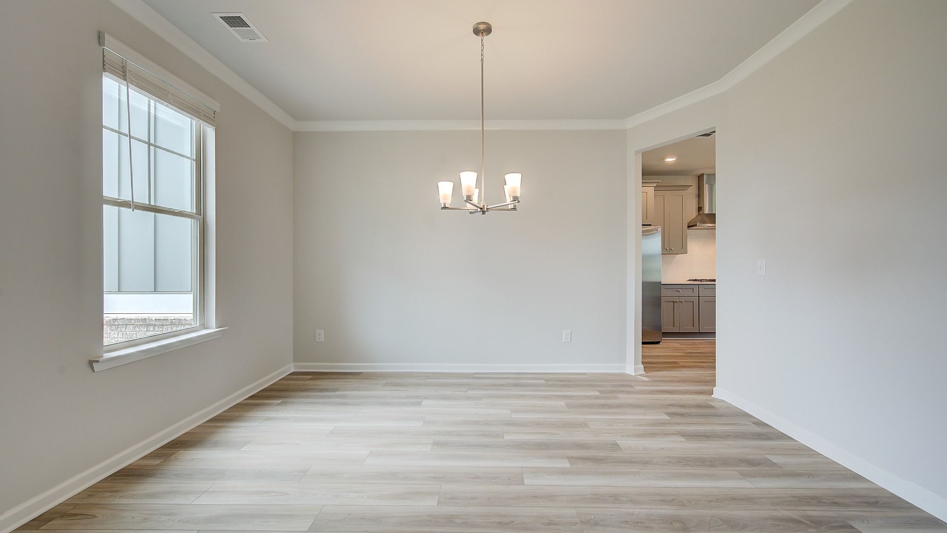 Meridian II dining room with coffered ceiling, box panel wainscoting, and LVP flooring at Brighton in Locust Grove, GA.