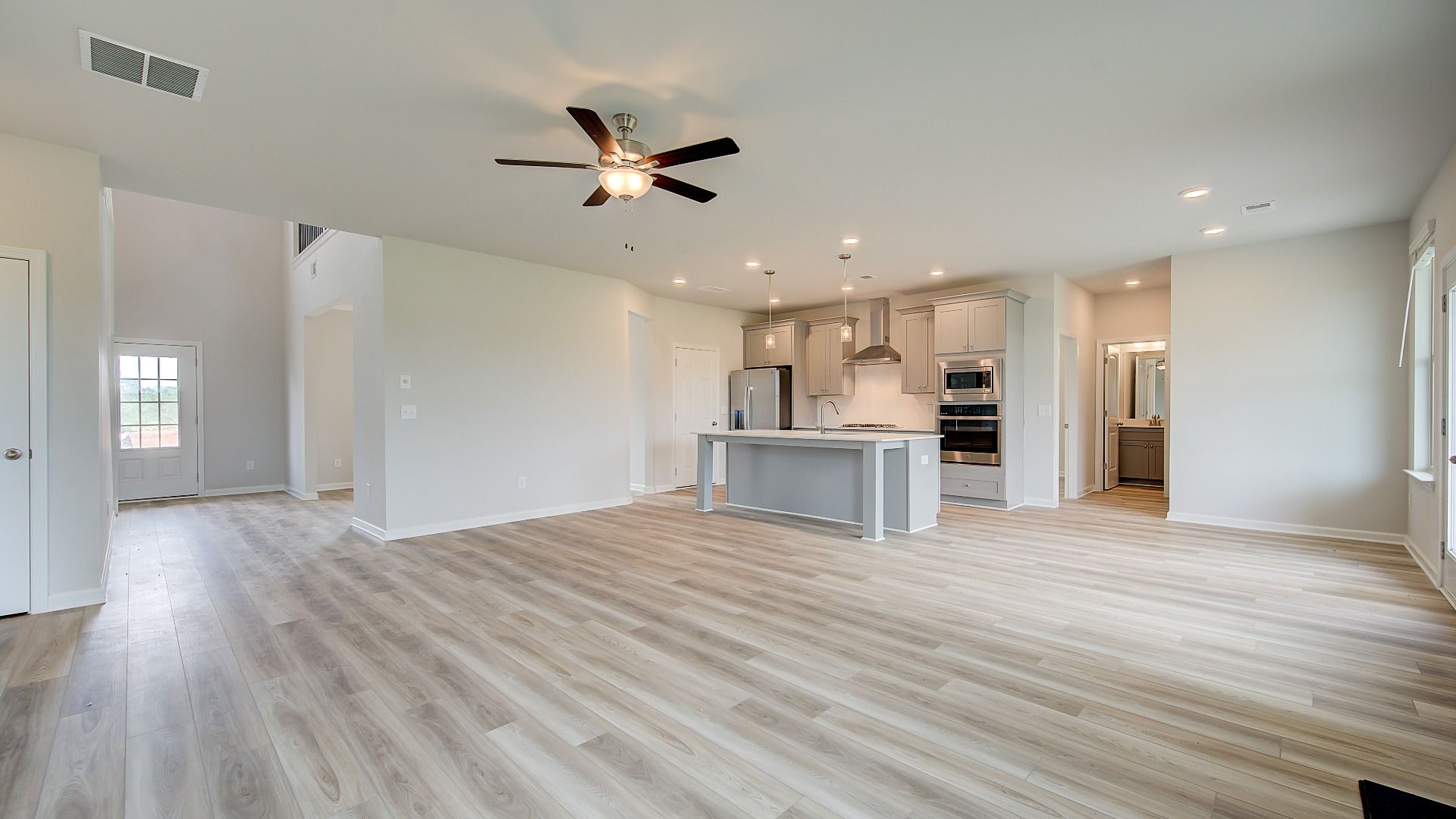 Expansive family room with LVP flooring, natural light, and ample space for seating fin the Meridian II at Brighton.