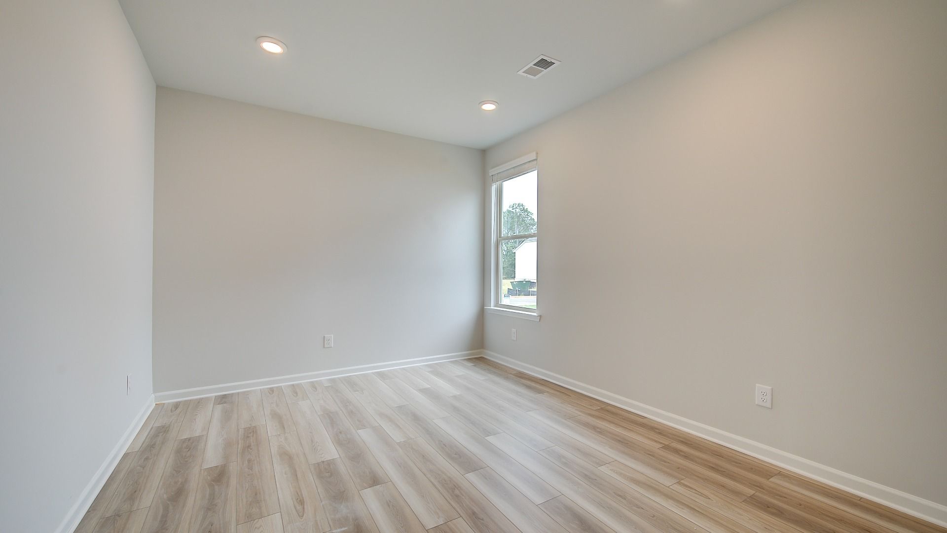 Meridian II first-floor study with carpet flooring and natural light at Brighton in Locust Grove, GA.