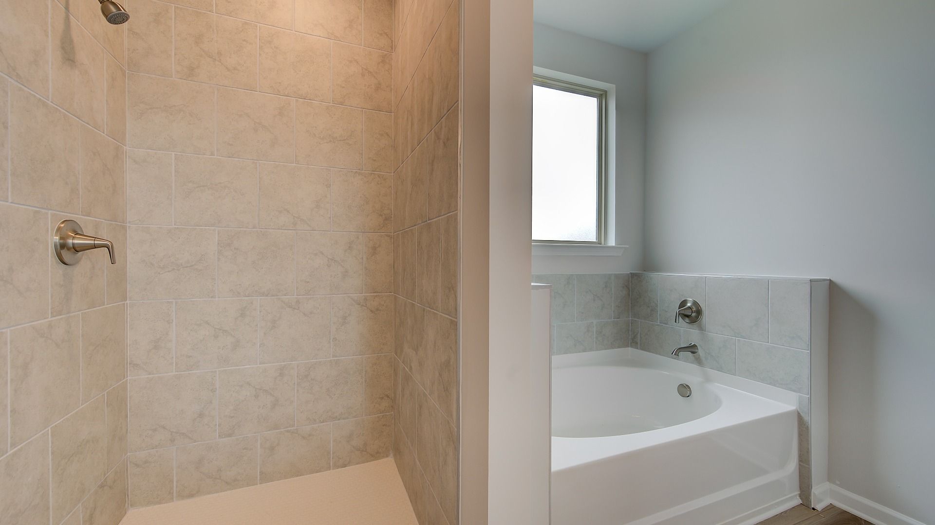 Meridian II primary bath with freestanding tub, walk-in shower, and modern tile design at Brighton in Locust Grove, GA.