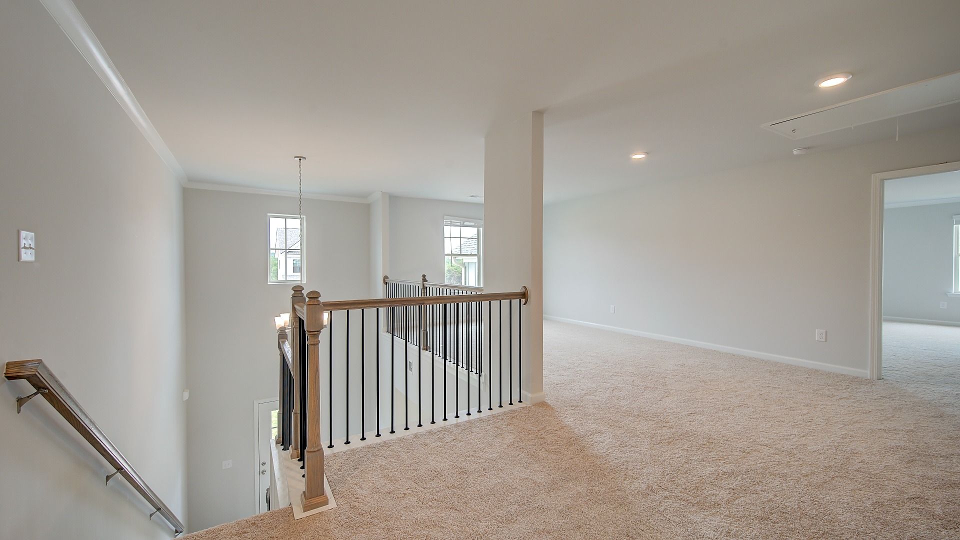 Open upstairs landing with carpet flooring leading to loft in the Meridian II at Brighton in Locust Grove, GA.