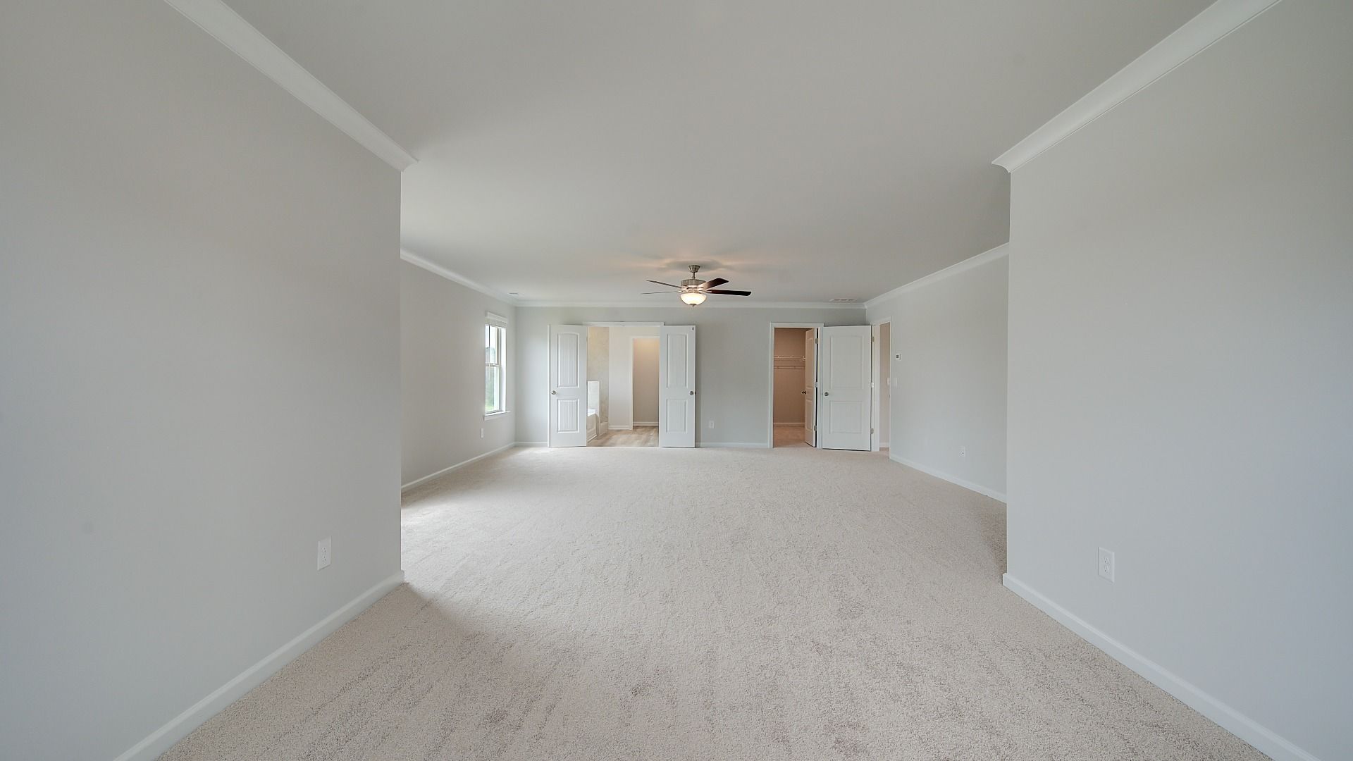 Meridian II primary suite sitting room with carpet flooring and spacious layout at Brighton in Locust Grove, GA.