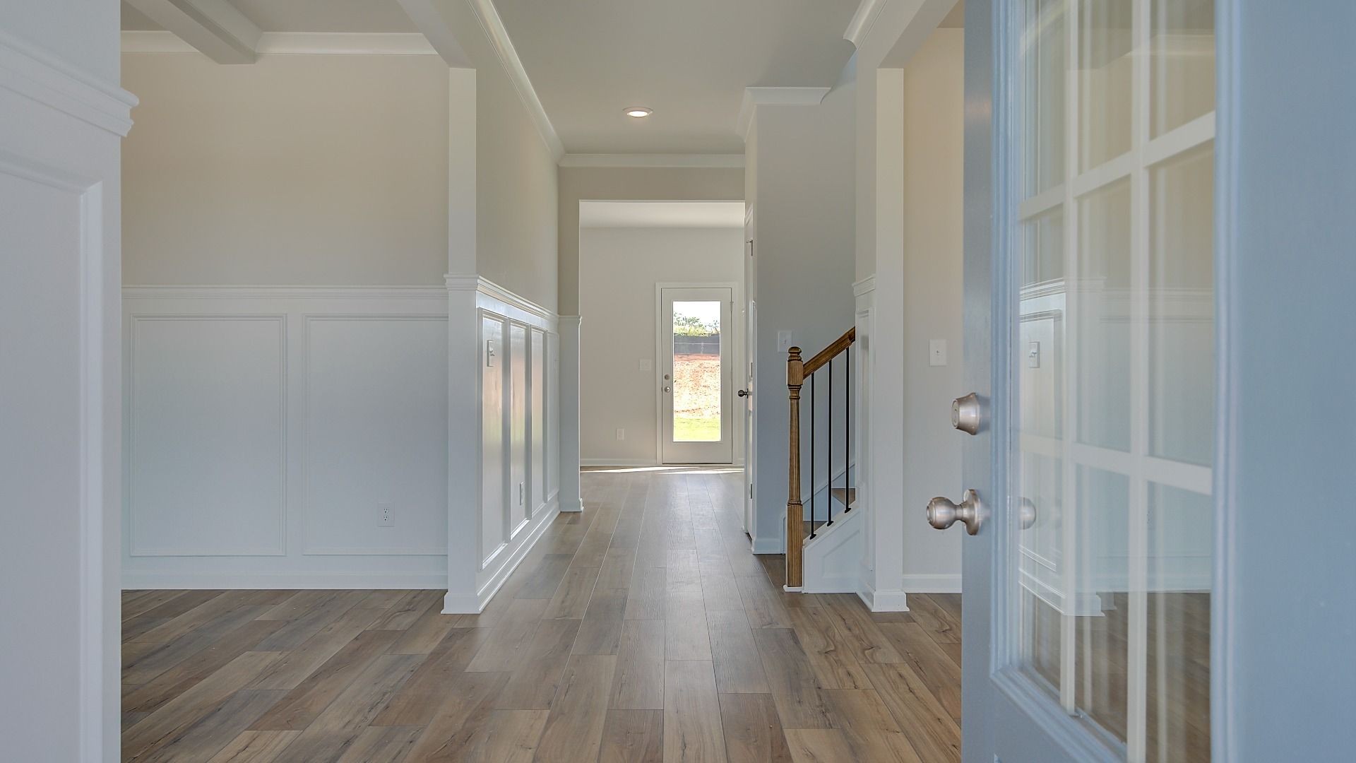 Stonefield entry with neutral front door, LVP flooring, and open foyer at Brighton in Locust Grove, GA.
