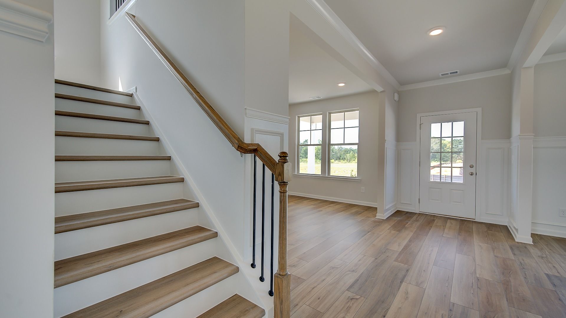 Stonefield foyer with open railing staircase and LVP flooring at Brighton in Locust Grove, GA.