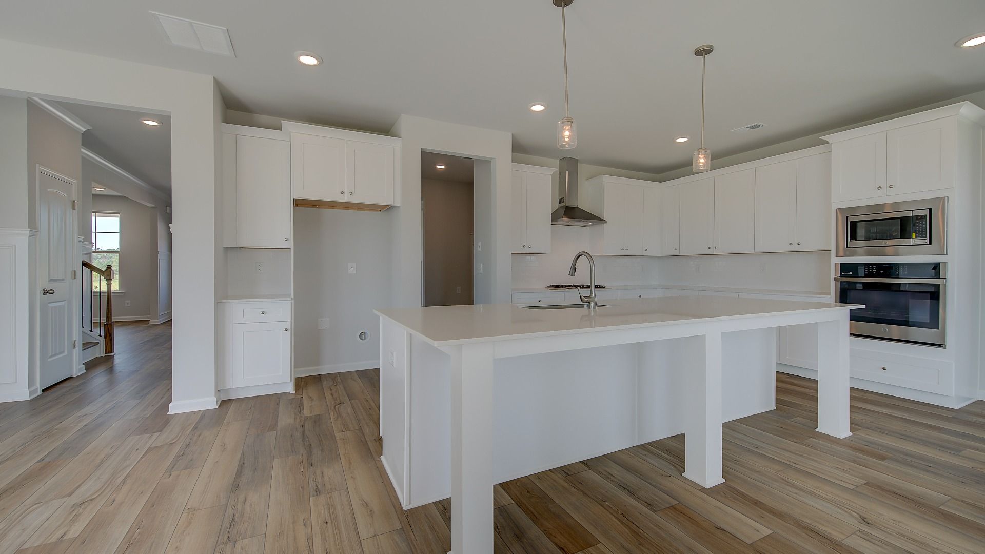 Stonefield open-concept kitchen with expansive island, neutral modern features, and adjoining breakfast area at Brighton.