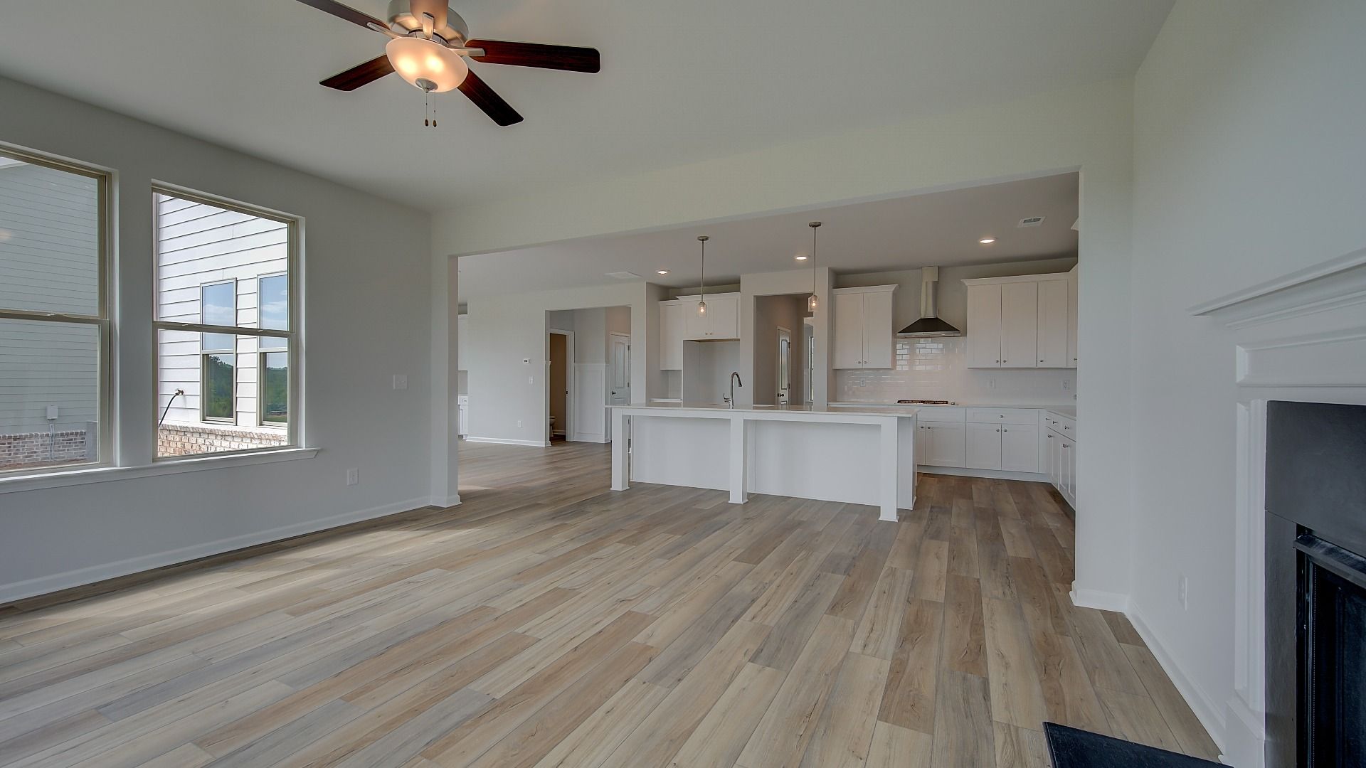 Stonefield open-concept family room with natural light, LVP flooring, and connection to kitchen at Brighton.