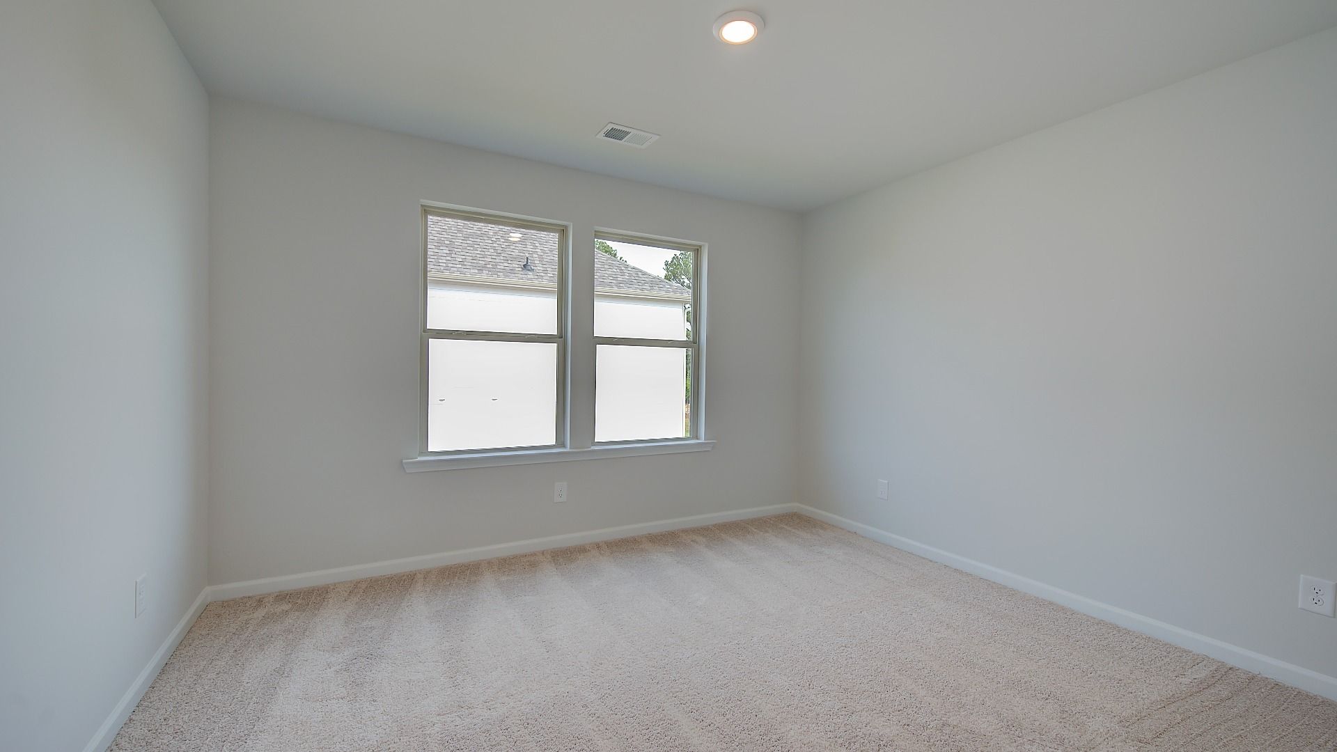 Secondary bedroom with tray ceiling, natural light, and carpet flooring in the Stonefield at Brighton.