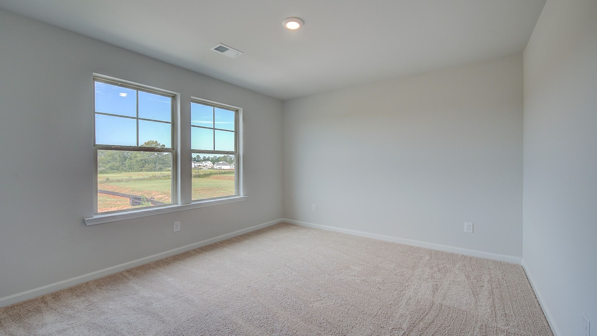 Secondary bedroom with connected closet, tray ceiling, and carpet flooring in the Stonefield at Brighton.