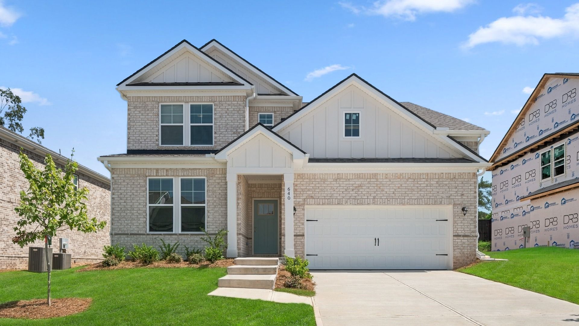 Wynwood two-story home with brick and stone accent exterior and two-car front-entry garage at Bowers Farm in McDonough, GA.