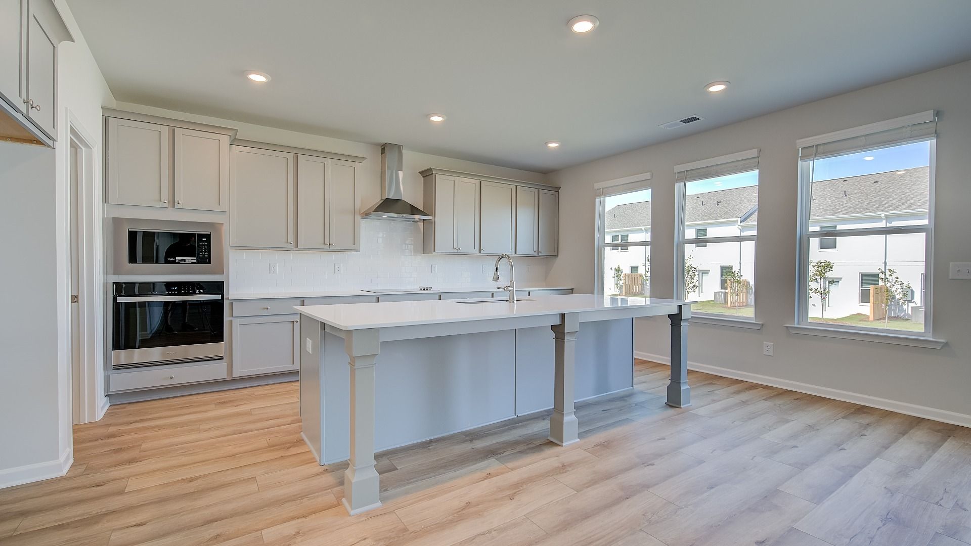 Open Ridgewood kitchen with bright modern features and oversized island with seating at Bowers Farm.
