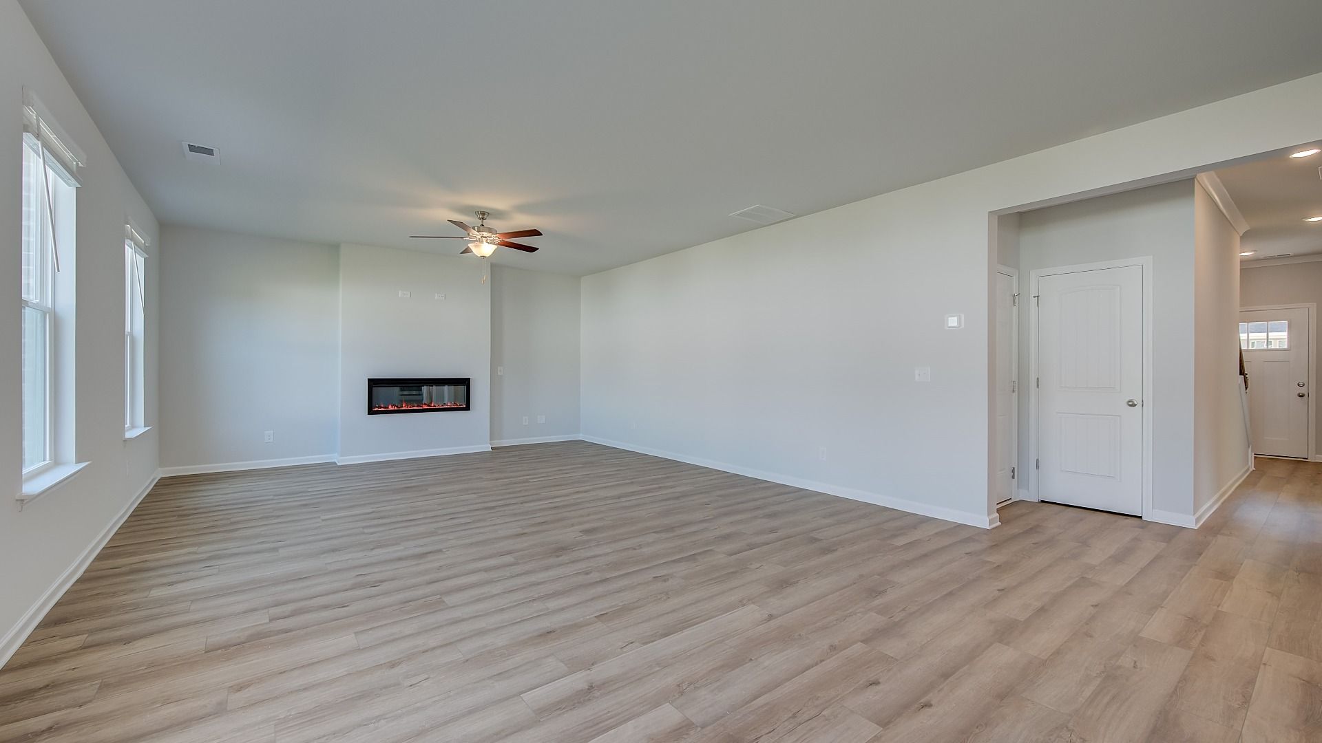 Expansive family room with LVP flooring, natural light, and electric fireplace in the Ridgewood at Bowers Farm.