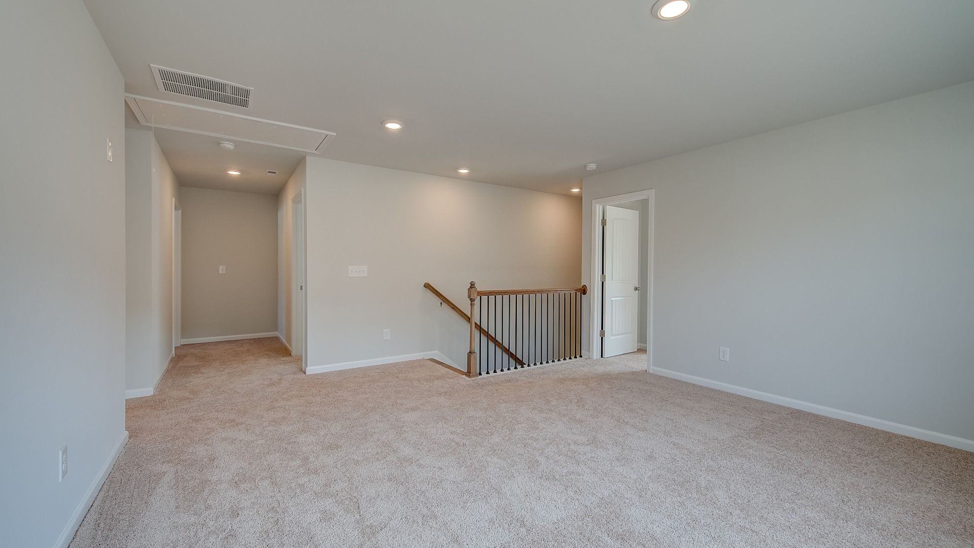 Spacious Ridgewood loft for work or lounge use with carpet flooring and natural light at Bowers Farm in McDonough, GA.