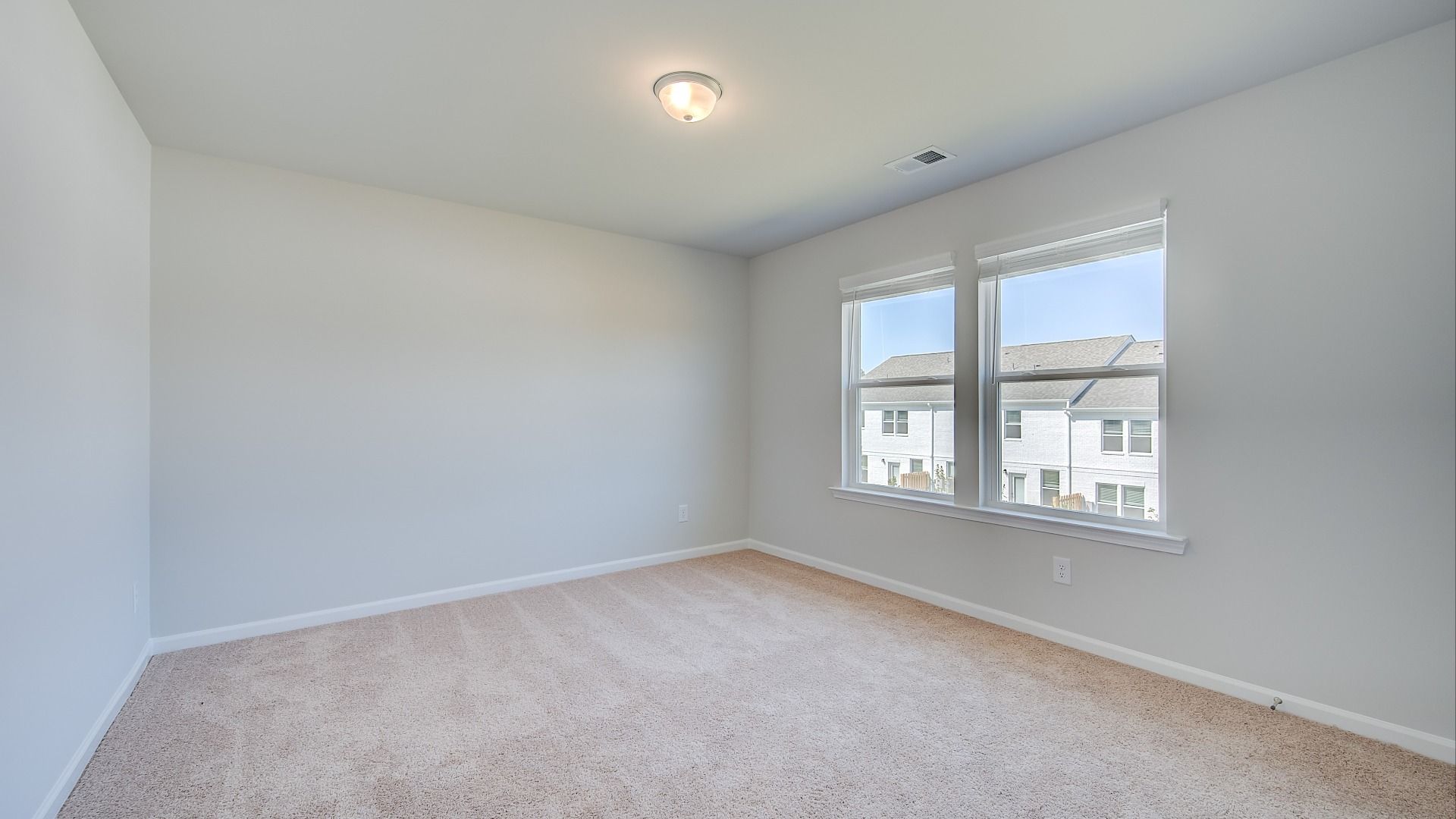 Comfortably sized Ridgewood secondary bedroom with carpet flooring and natural light at Bowers Farm in McDonough, GA.