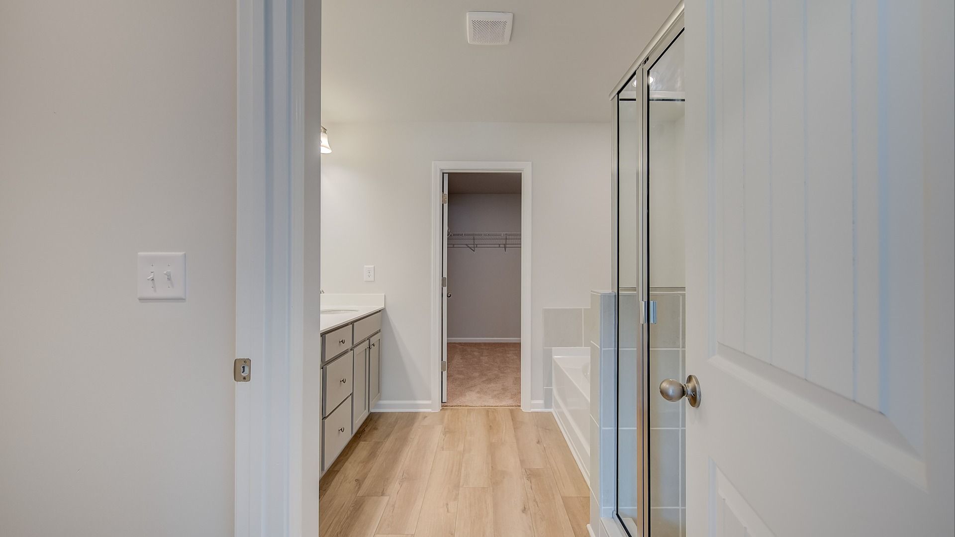 Ridgewood primary bath connecting to primary suite featuring dual vanities, tub and walk-in shower at Bowers Farm.