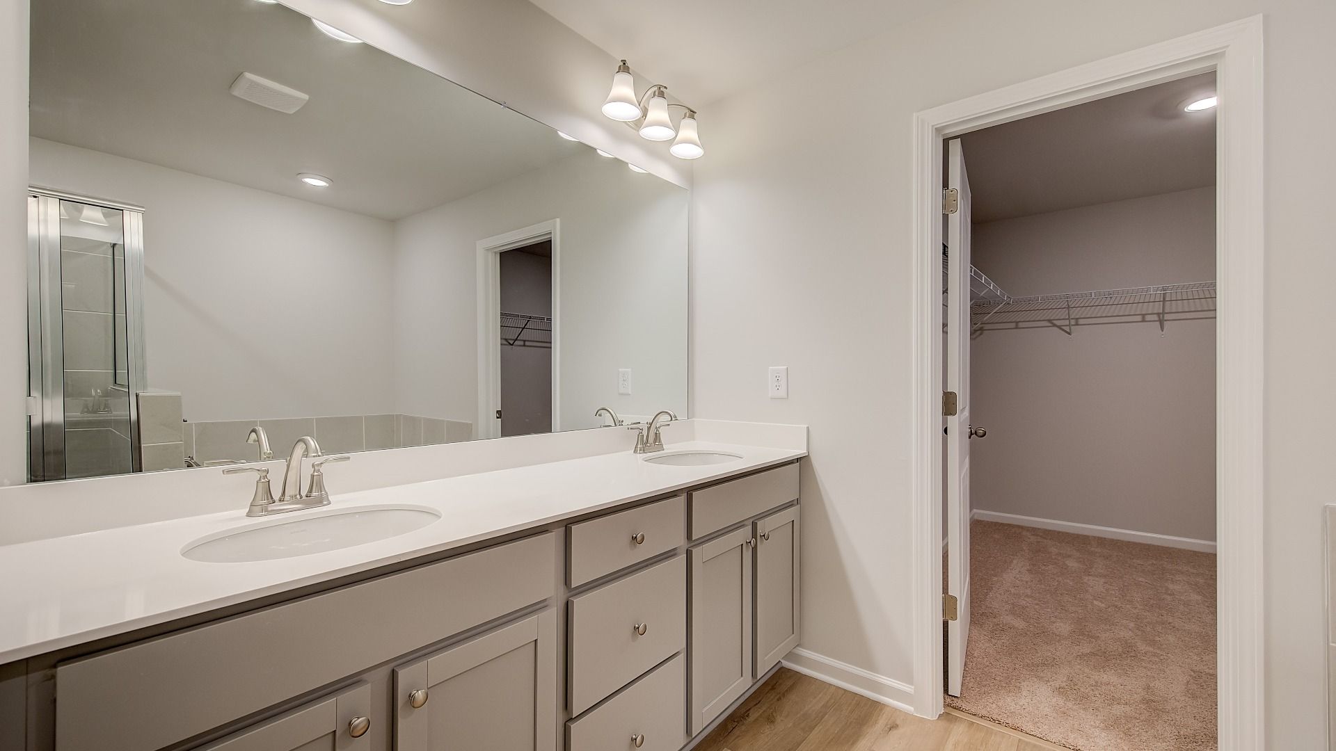 Ridgewood bright and modern primary bath with dual vanities with quartz countertops at Bowers Farm.