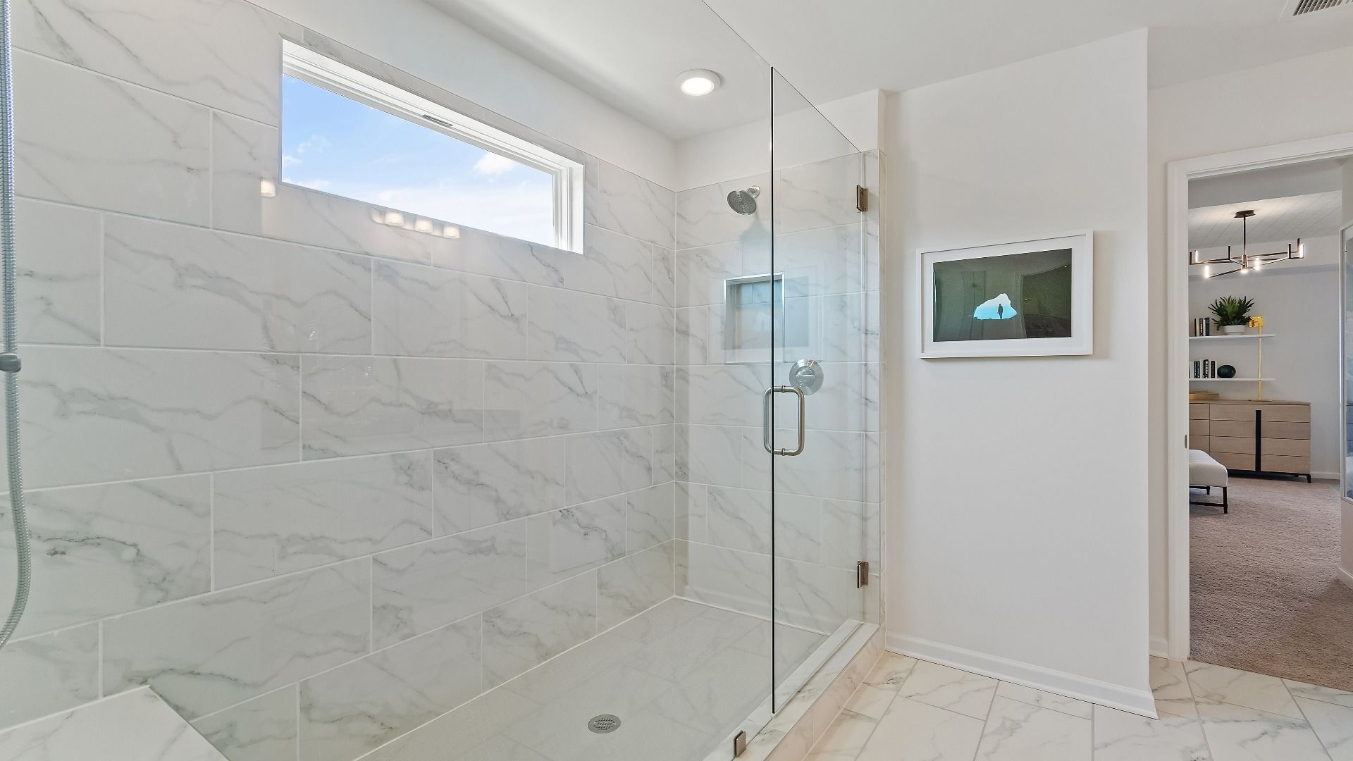 Wagener primary bath with elegant modern detail and tiled walk-in shower at Bowers Farm in McDonough, GA.