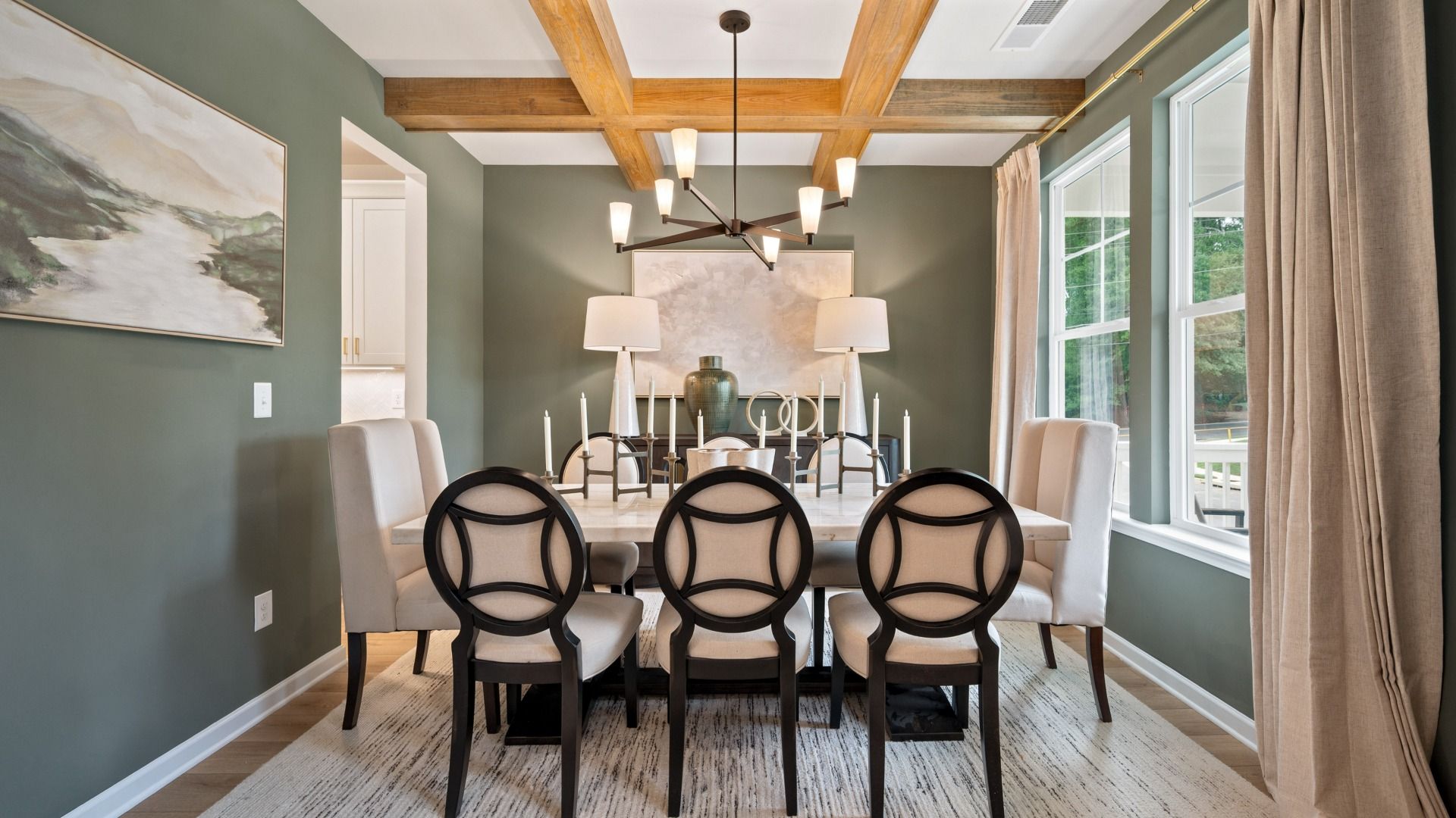 Bright Rosemary II dining room with coffered ceiling, wall panel molding, and LVP flooring at Brighton in Locust Grove, GA.