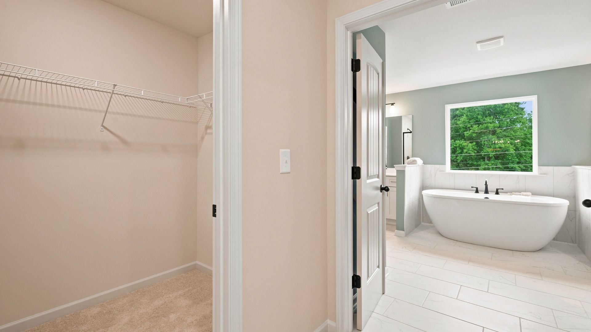 Rosemary II primary walk-in closet connected to primary bath with built-in shelving at Brighton in Locust Grove, GA.