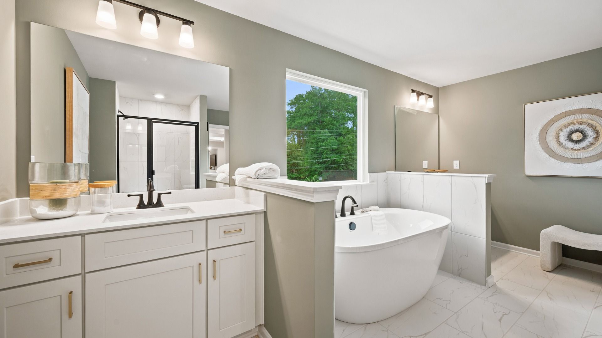 Modern primary bath with dual vanities, freestanding tub, and dark tile flooring in the Rosemary II at Brighton.