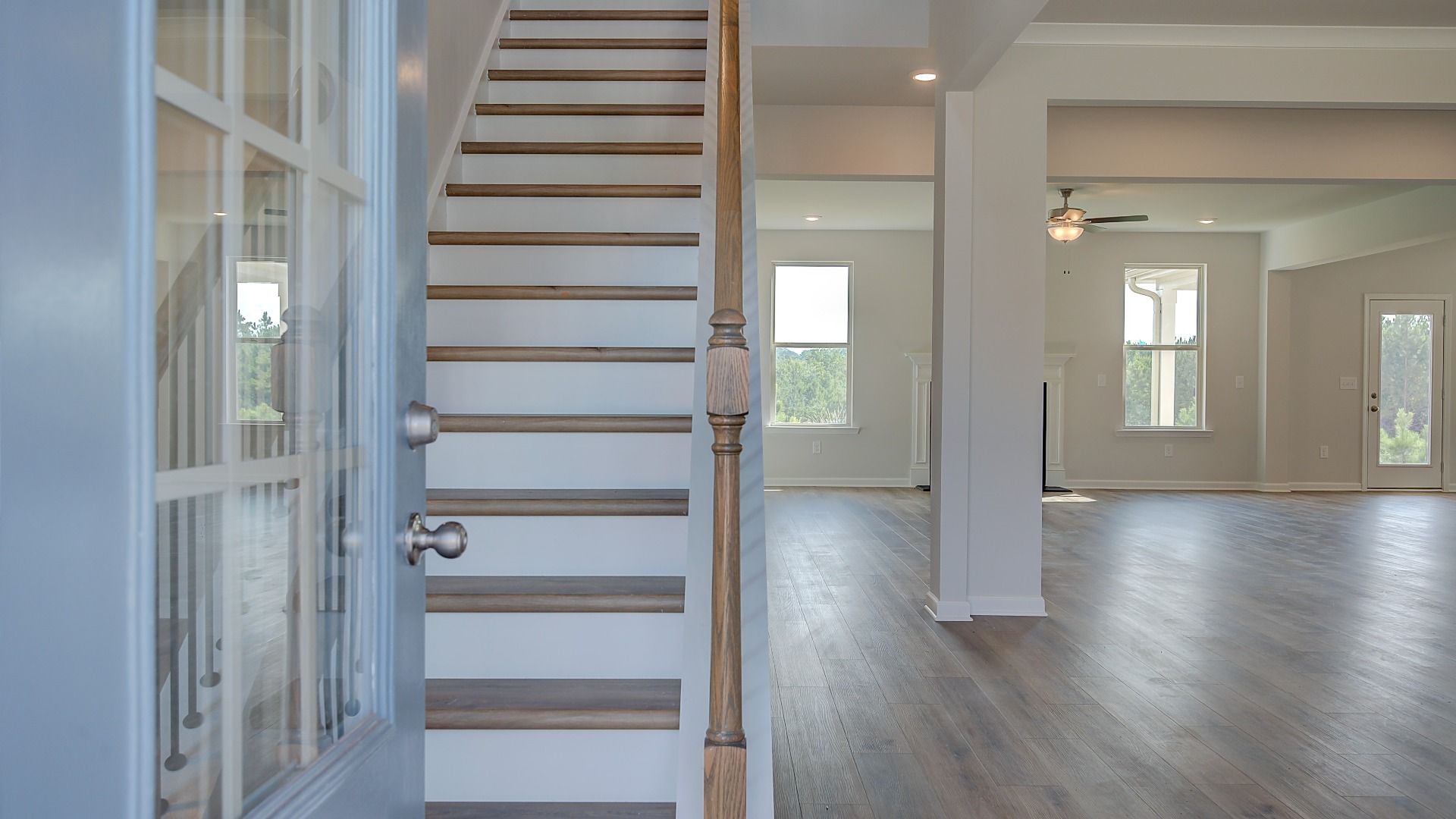 McKinley II front door with glass panels opening to foyer with LVP flooring at Brighton in Locust Grove, GA.
