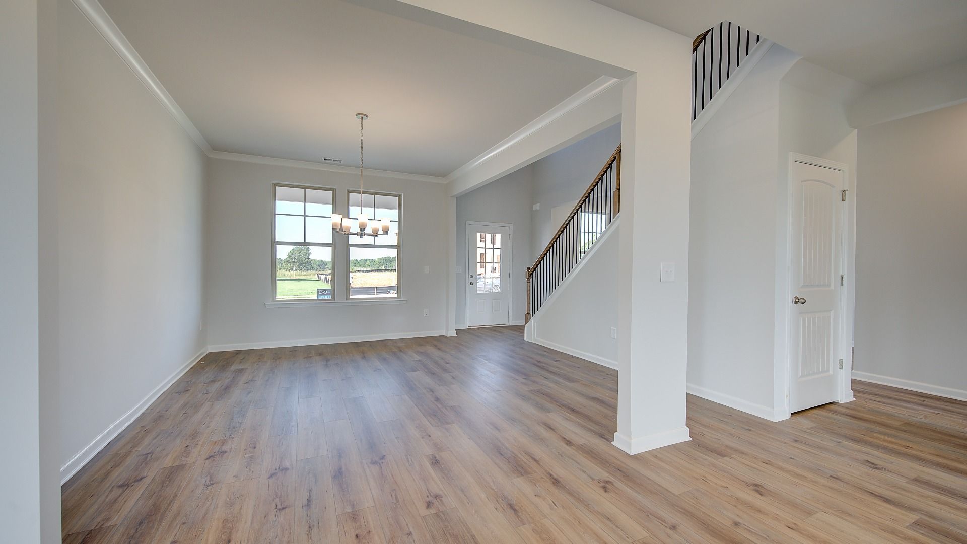 Open dining room with coffered ceiling and LVP flooring in the McKinley II at Brighton in Locust Grove, GA.