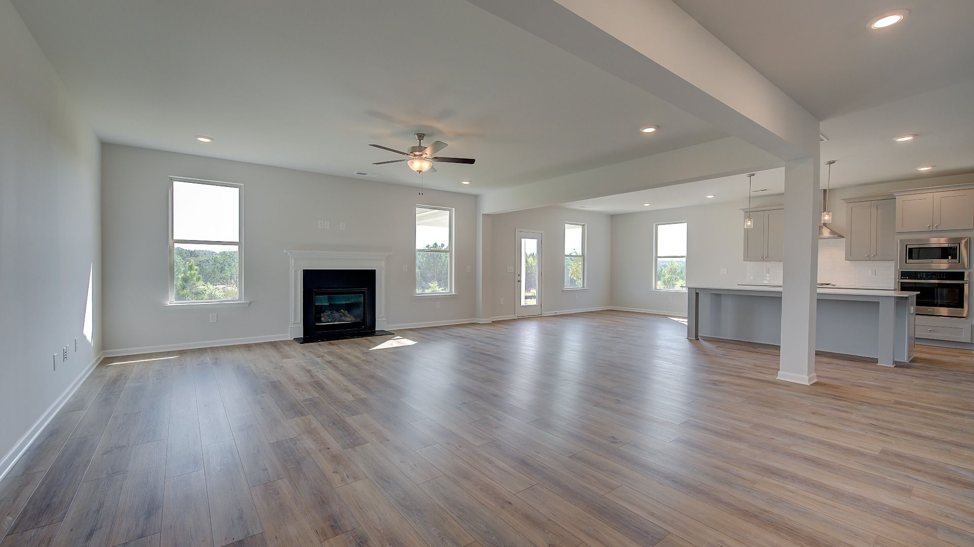 Open-concept family room with gas fireplace, abundant seating area, and LVP flooring in the McKinley II at Brighton.