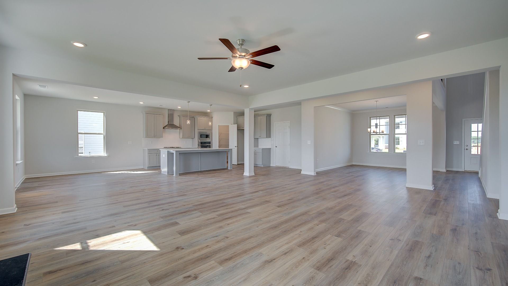 McKinley II open-concept family room with ceiling fan lighting and LVP flooring at Brighton in Locust Grove, GA.