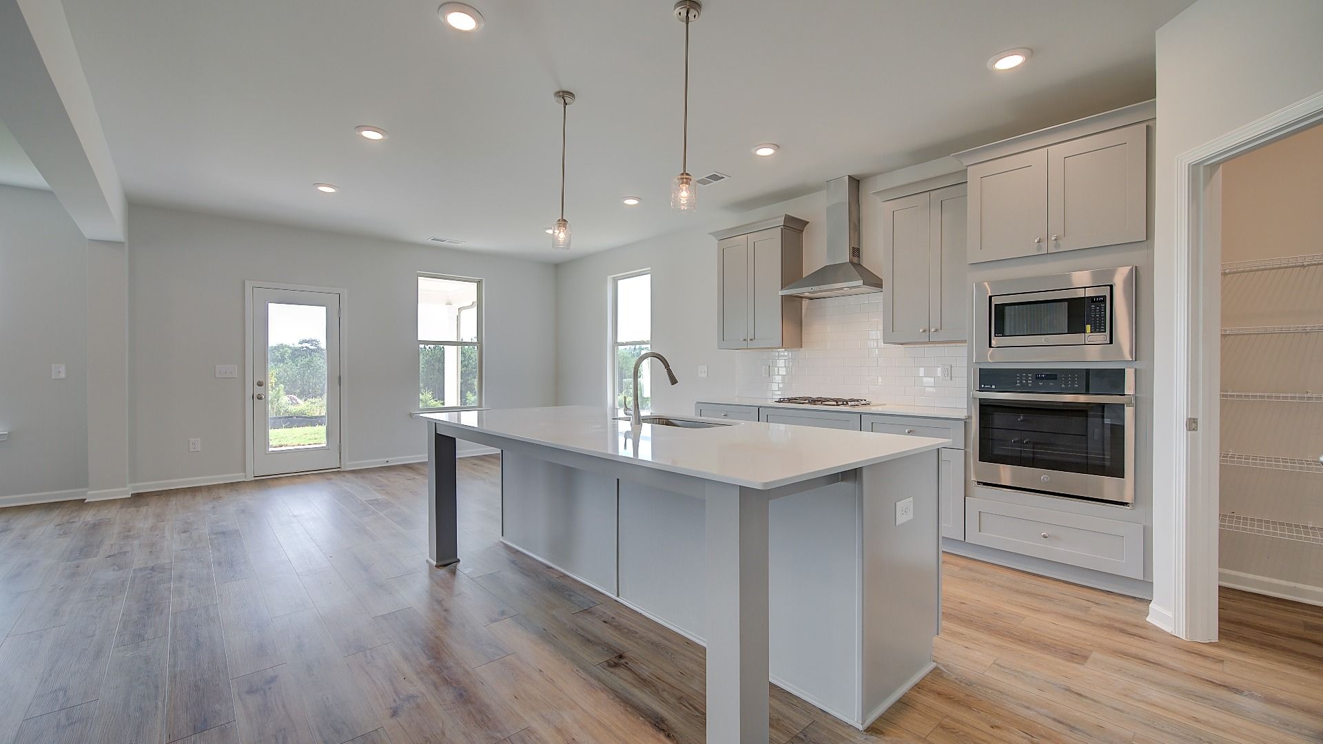 Gourmet kitchen with oversized island, pendant lighting, and white cabinetry in the McKinley II at Brighton.