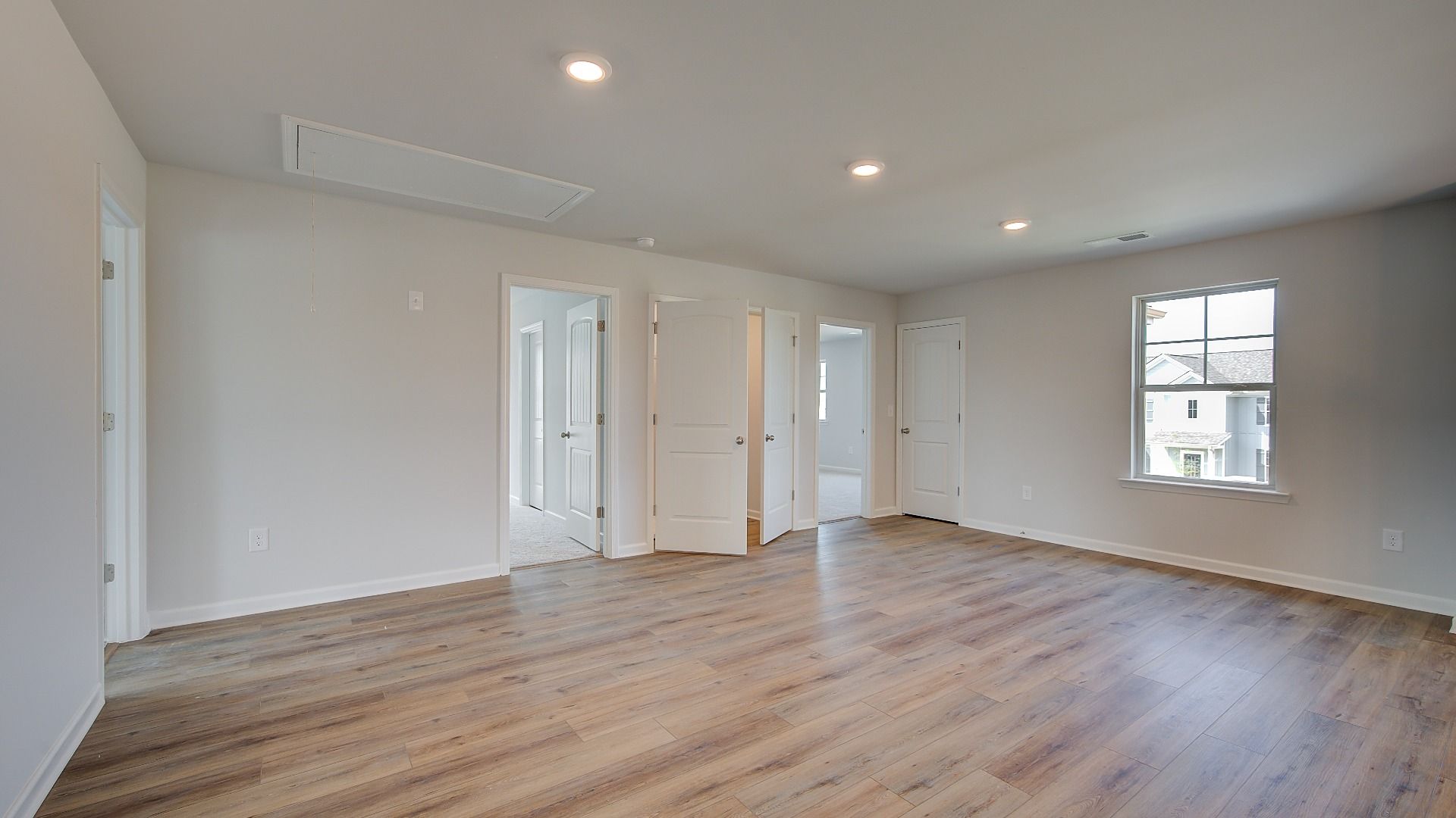 McKinley II spacious loft with carpet flooring, natural light, and ceiling fan light at Brighton in Locust Grove, GA.
