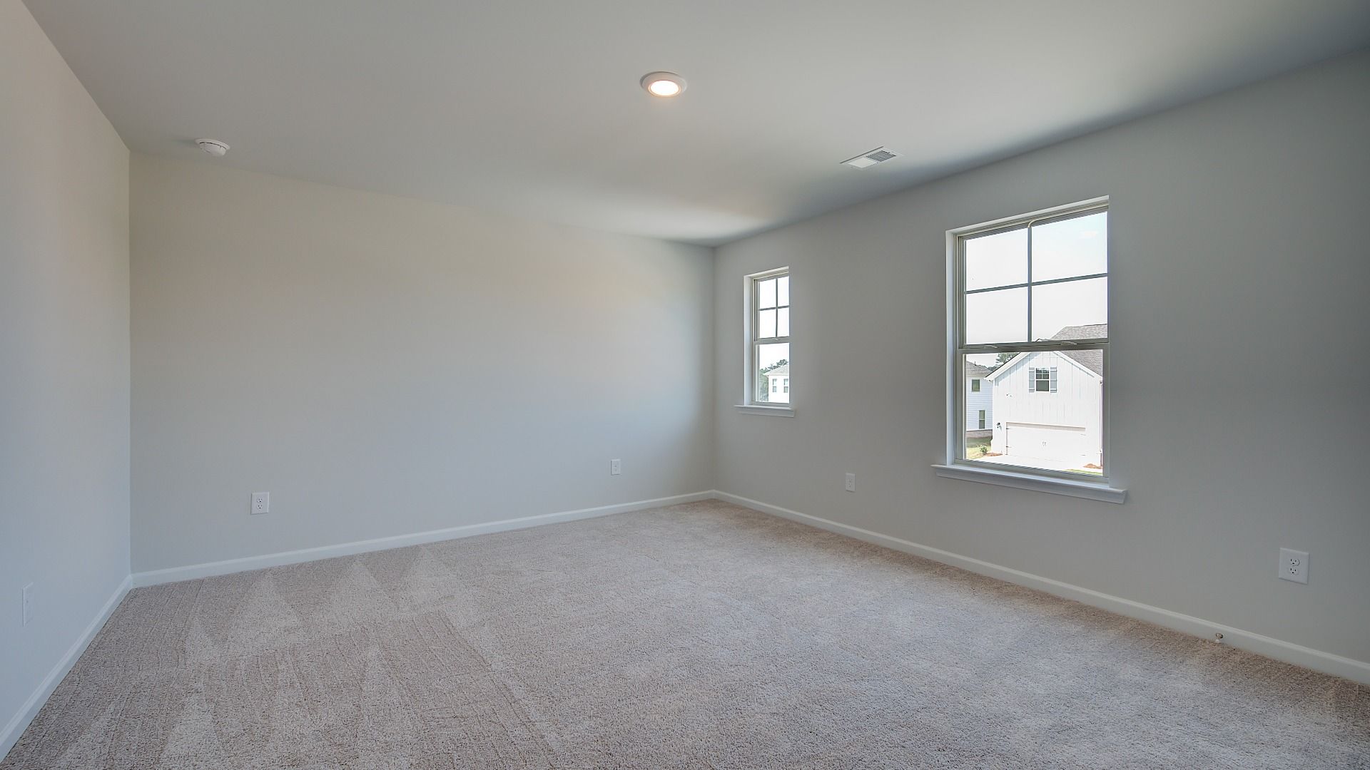 Secondary bedroom with carpet flooring and natural light in the McKinley II at Brighton in Locust Grove, GA.